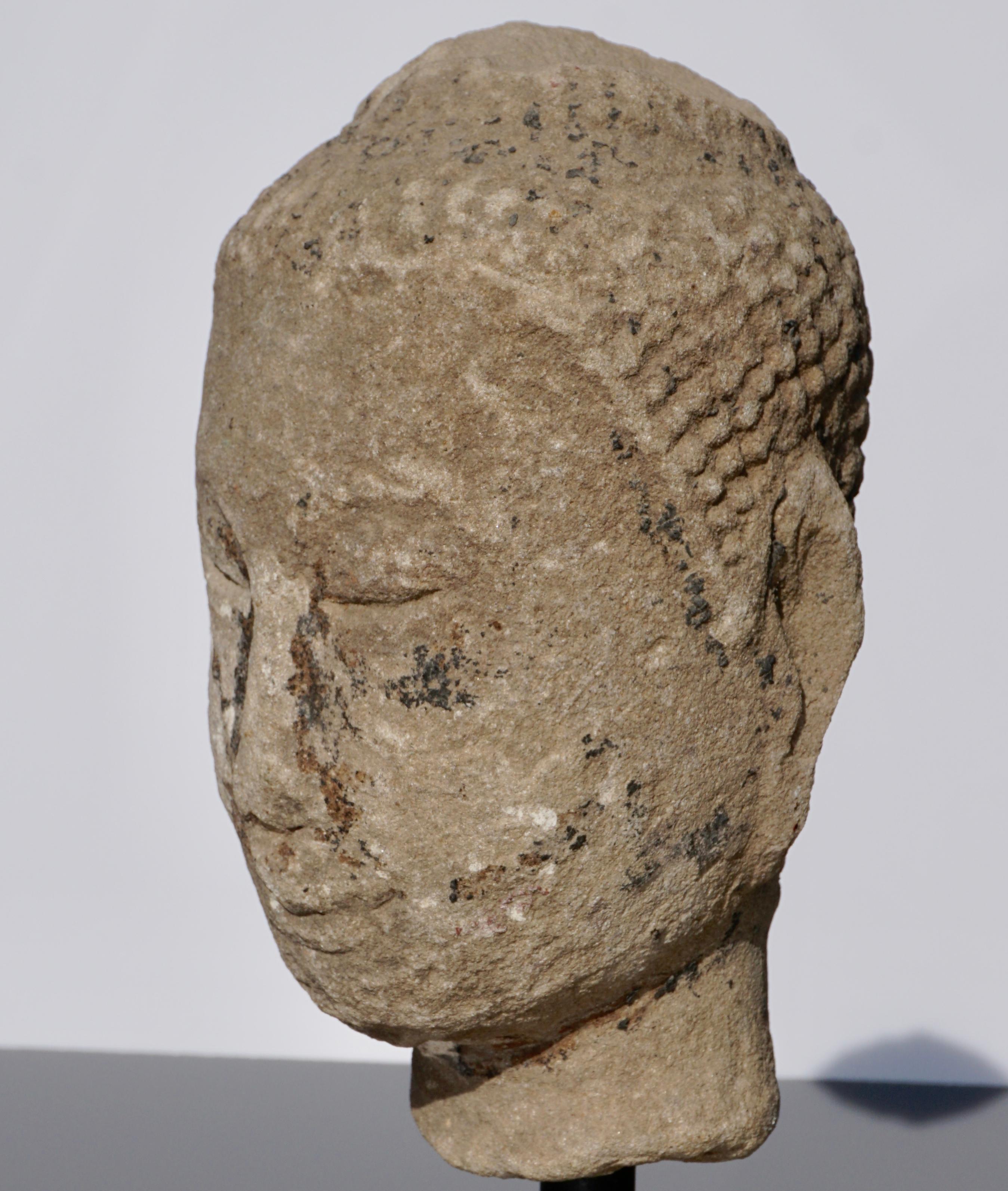 A very serene and calming weathered sandstone Buddha head from Thailand, circa 16th century or earlier. Traces of polychrome and golf pigments throughout. Gilding around nose looks like tears eminatinting from Buddha’s tear ducts.. I love the