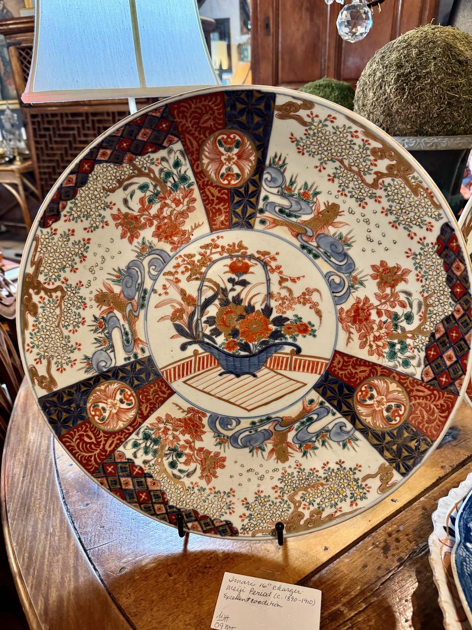 Il s'agit d'un très grand chargeur Imari datant de la fin de la période Meiji. Le chargeur est orné d'une réserve centrale représentant un panier de fleurs japonais traditionnel ; le panier est entouré de réserves représentant les 