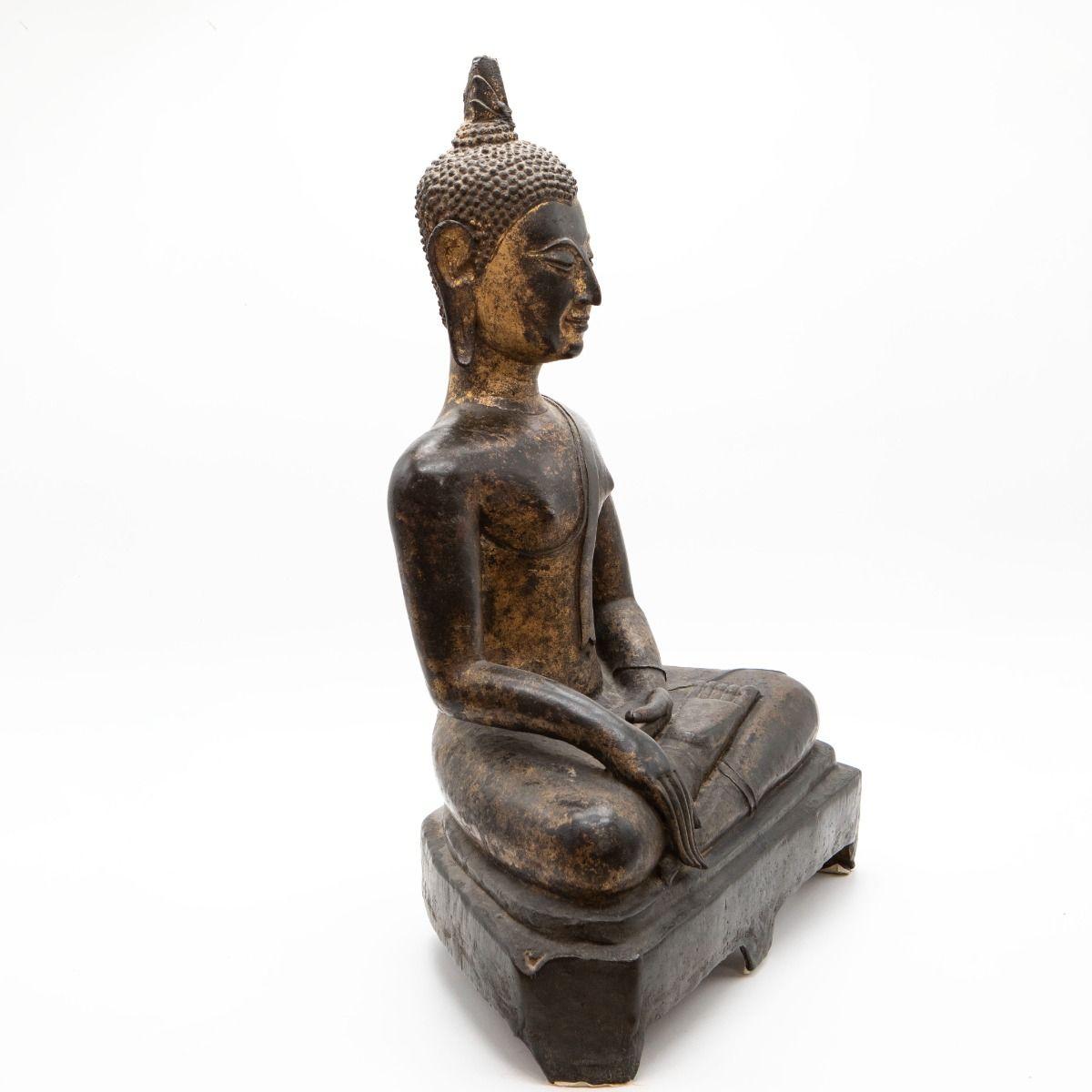 Un rare et impressionnant Bouddha de Siam de style Sukhothai, coulé en bronze avec des traces de dorure d'origine.
Créée au Siam (Thaïlande) au cours des XVIe et XVIIe siècles, la figure est assise en dhyanasana (méditation) sur une base
