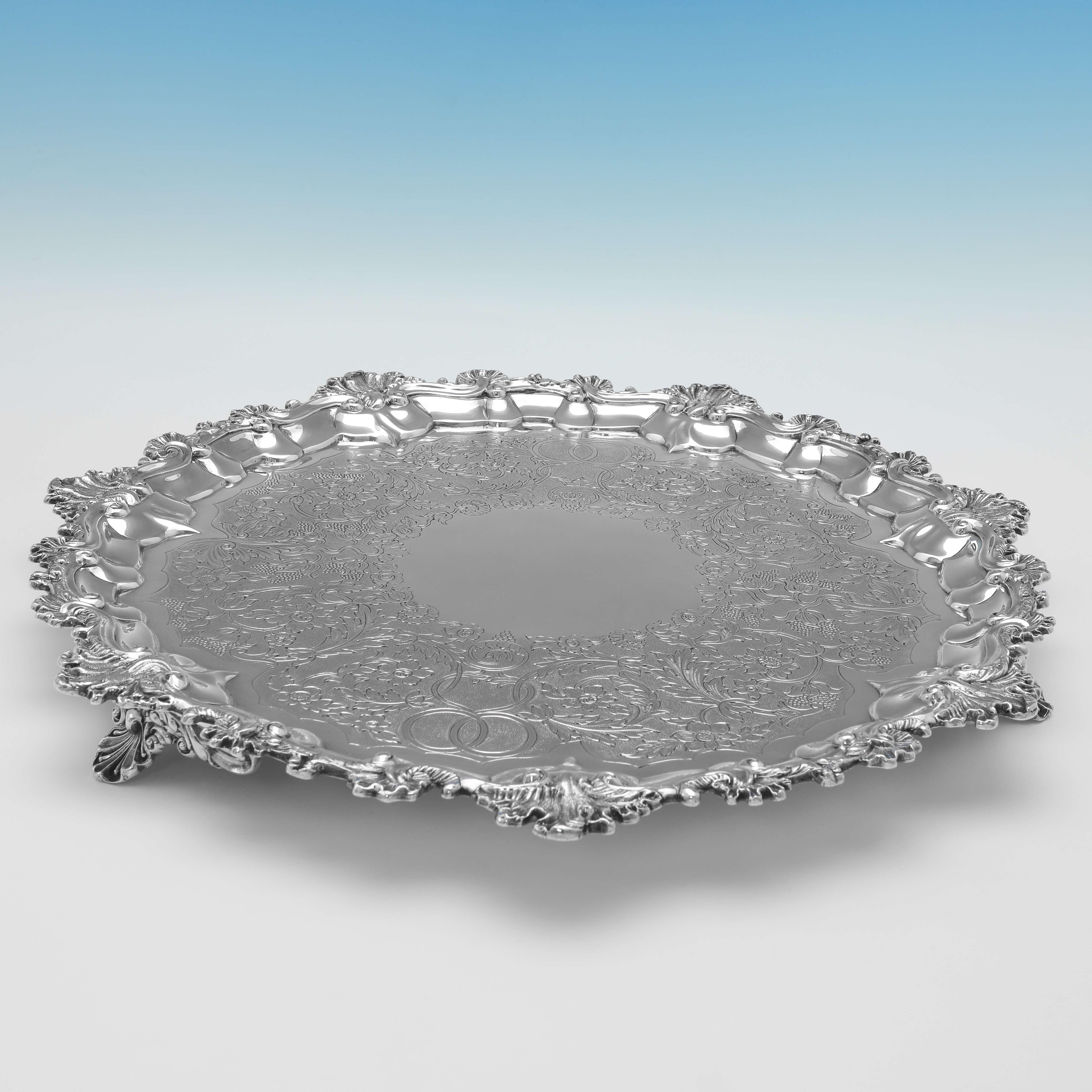 Hallmarked in London in 1836 by Hayne & Cater, this attractive, William IV, Antique Sterling Silver Salver, stands on three shell feet, and features a shell and scroll border, and flat chased decoration to the centre. 

The salver measures