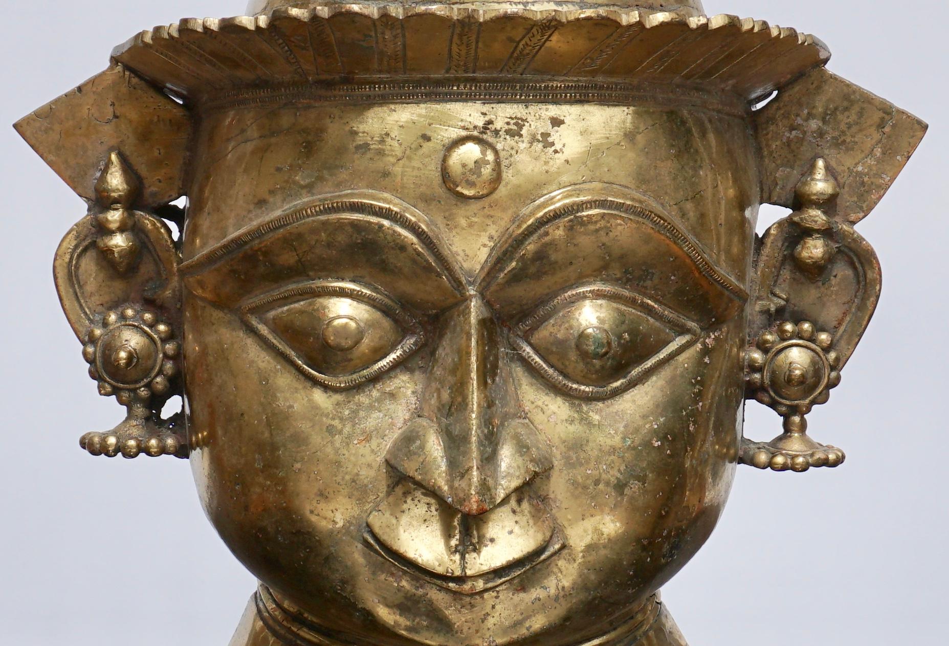 A Indian Mukhalingam Mukha face Lingum mask.

large and decorative gilt bronze Shiva facial representation of a Hindu God for phalic Lingums. A rare ritual artistic artifact.

Dimensions: 18.25 x 12.5 x 5.5 inches (46.4 x 31.8 x 14.0 cm)

Condition: