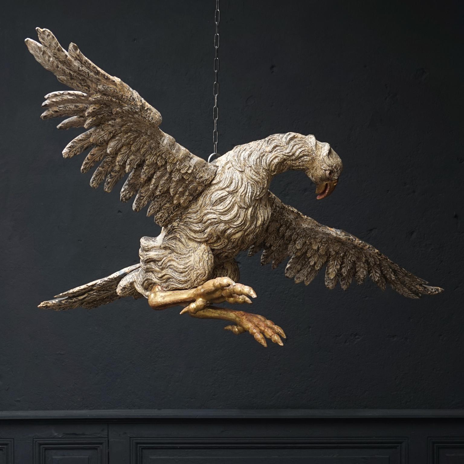 This is a very rare large antique hand carved, polychromed and gilt eagle.
Unbelievable workmanship went into making this wooden bird of prey sculpture with spread wings. 

Maybe it used to be part of a larger presentation, probably in a church, but