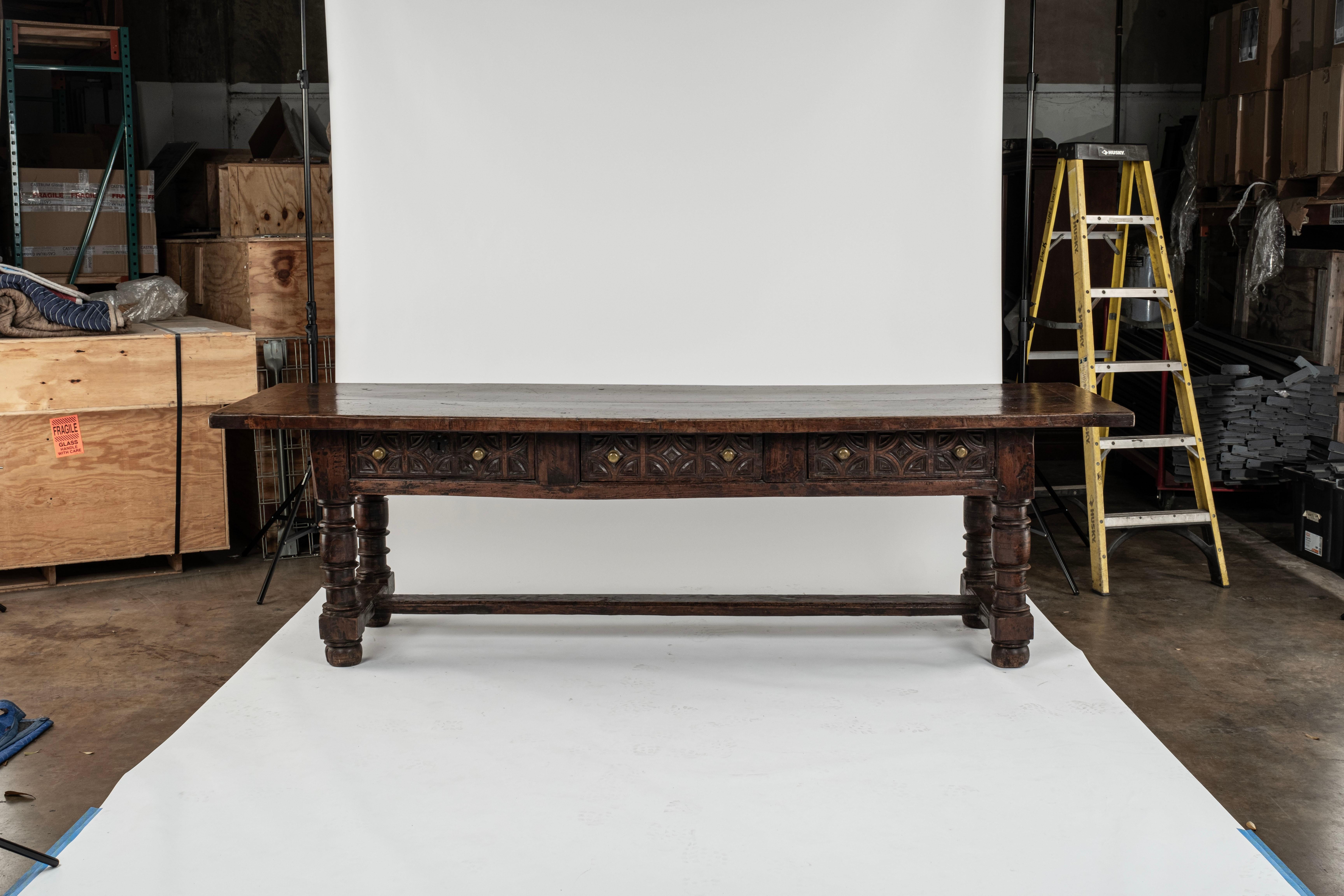 Grande table en noyer espagnole du 17e siècle  Importante table en noyer espagnole du XVIIe siècle. Un magnifique plateau à deux planches avec des extrémités clivées et trois tiroirs en dessous sur un côté, avec des motifs décoratifs profondément