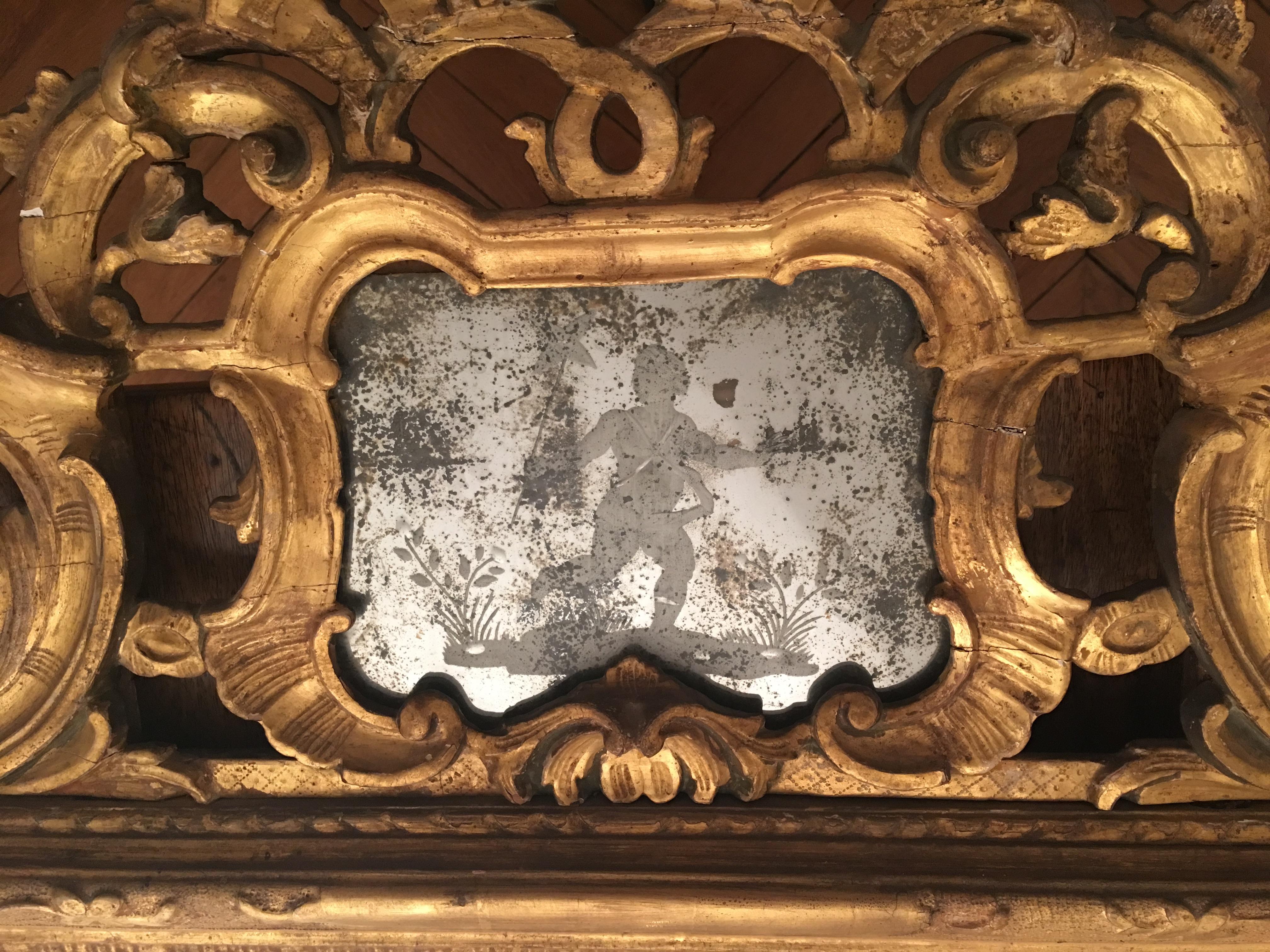 This exceptional mirror presents an undulating openworked frame showing a flower, waterleaf and scroll decor. 

The frame is topped by a large pediment with a central engraved glass cartouche showing putti playing amongst flowers. This cartouche