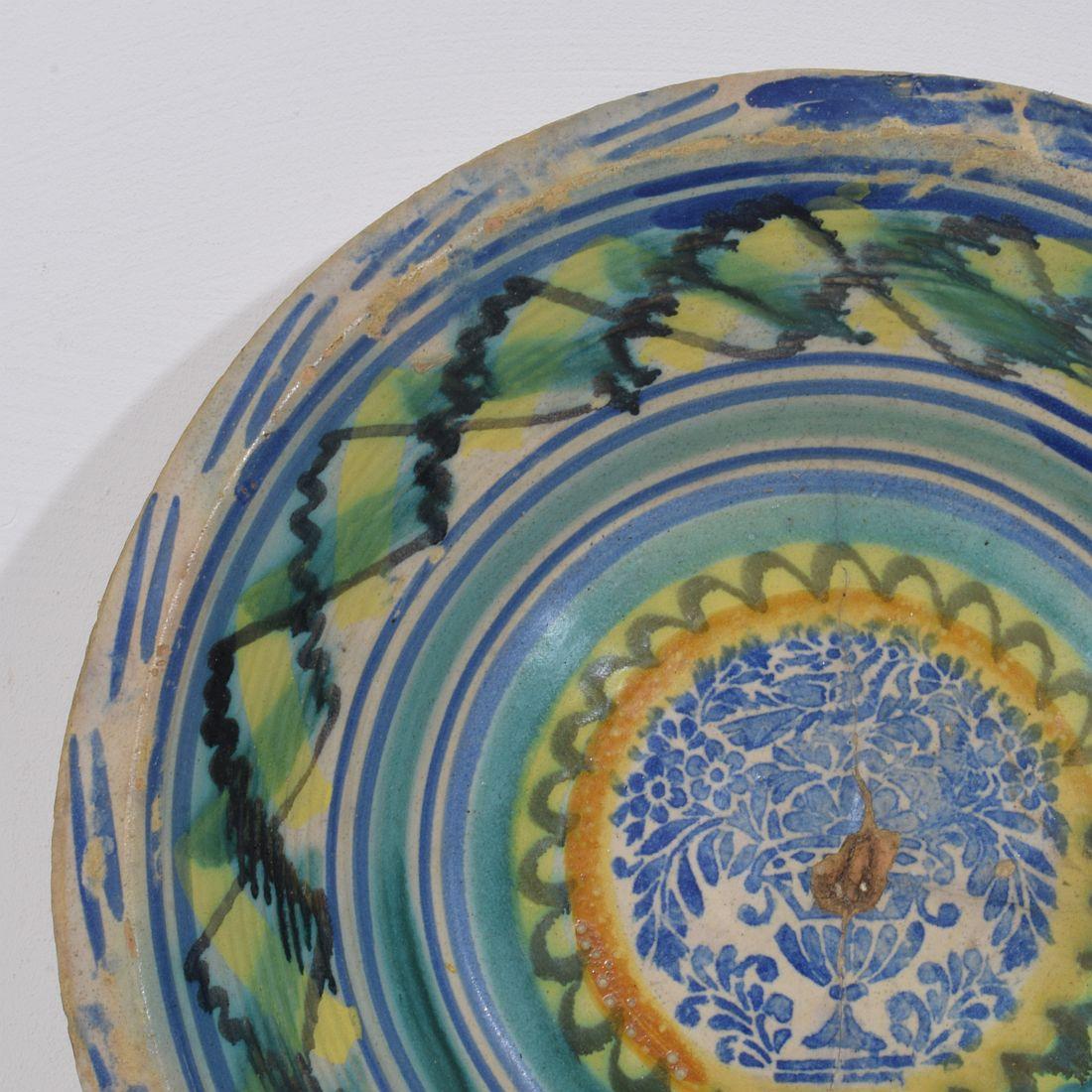 Very rare and  beautiful Spanish earthenware bowl. Wonderful decoration with a bird sitting on a vase of flowers
Sevilla, Spain, circa 1750-1850
Weathered and amazing antique repair ( see photo's)
H:10,5cm  W:43cm