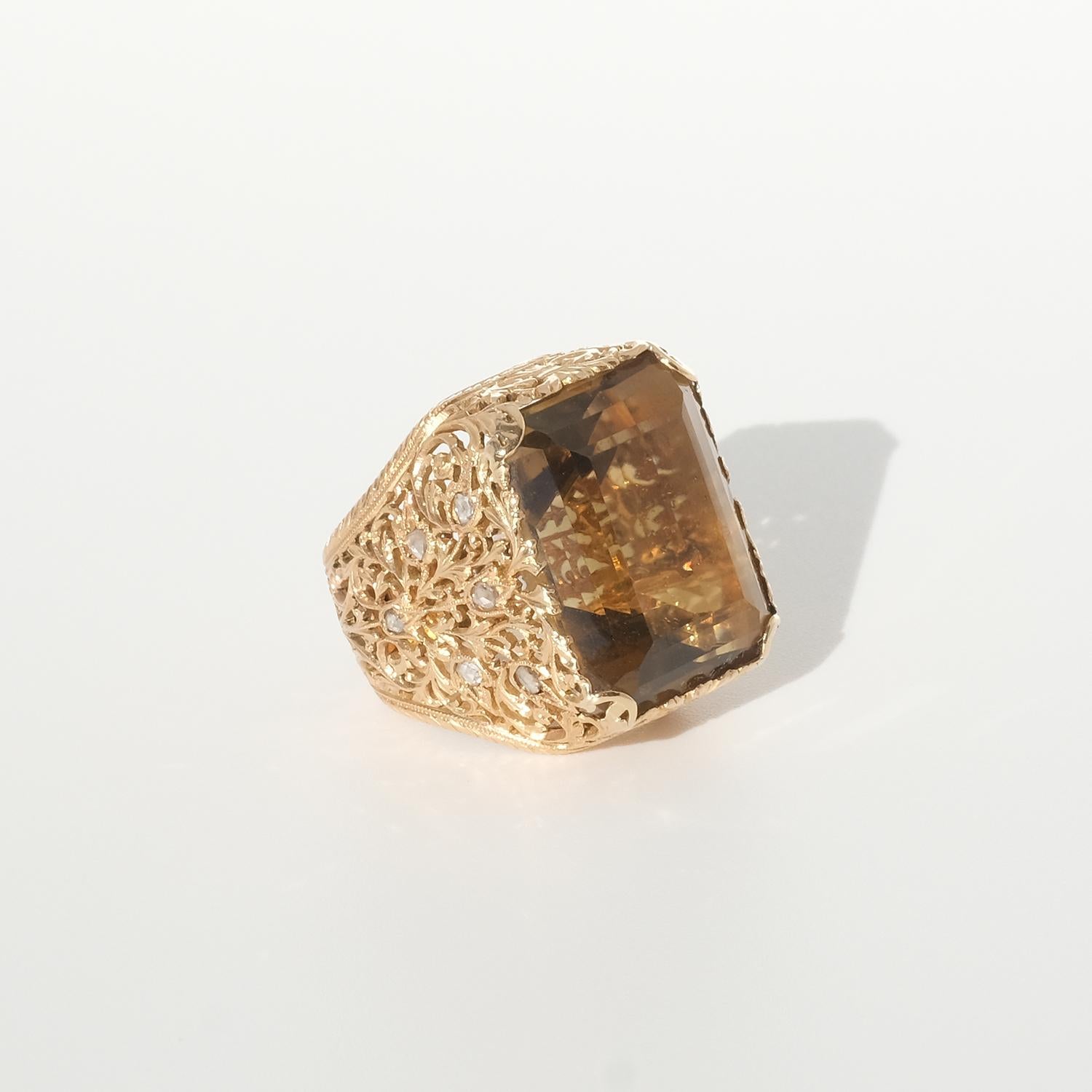 Dieser Ring aus 18 Karat Gold hat einen großen, rechteckigen, braunen Citrin im Treppenschliff. Sein Goldschaft und seine Fassung sind mit einem schönen Rocaille-Muster und sechs Diamanten im Rosenschliff auf jeder Seite verziert. Die Qualität der