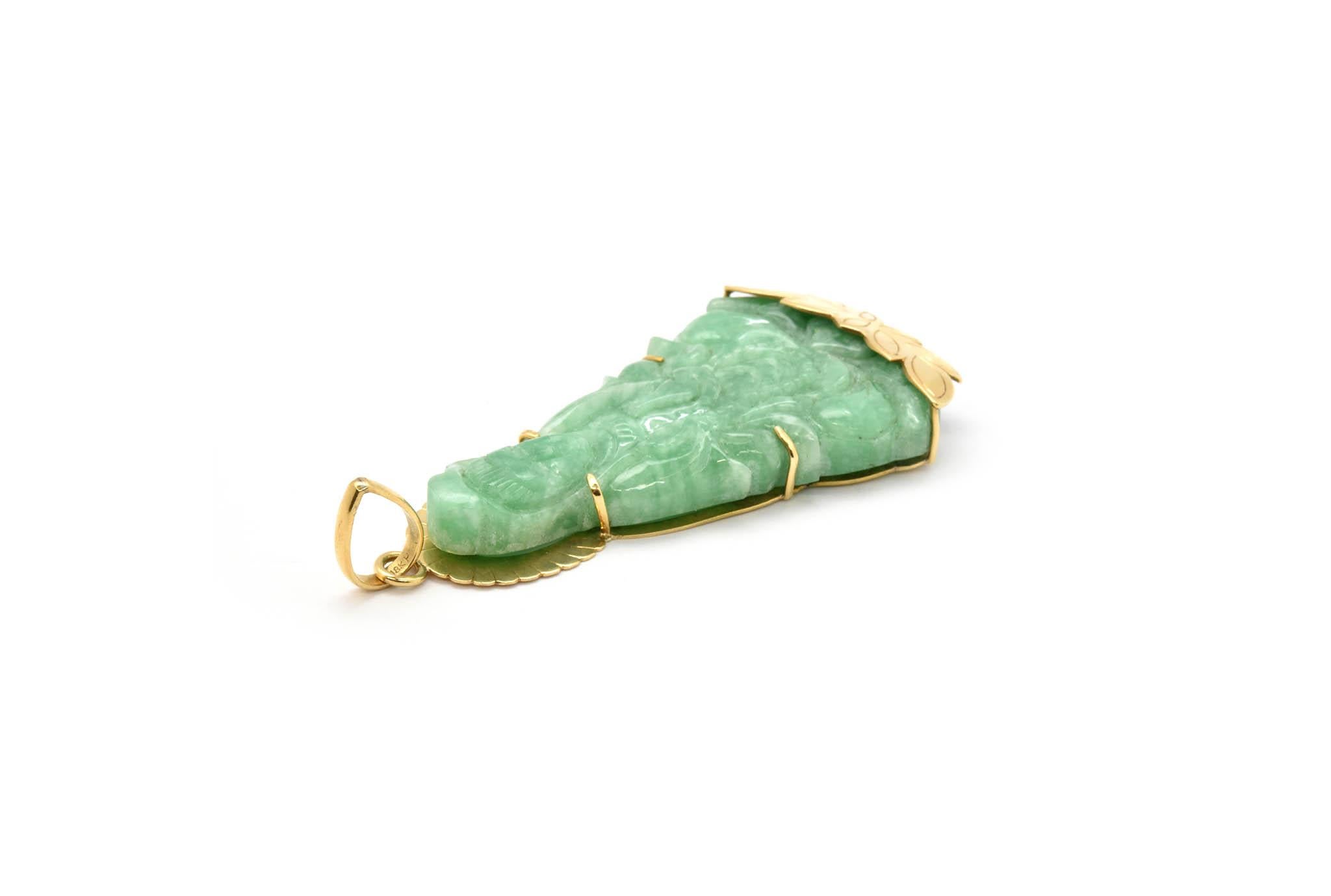 This fantastic pendant features a piece of carved green jade set into 14k yellow gold. The jade is carved into a Buddha. The pendant measures 92x40mm, and it weighs 52.05 grams. 