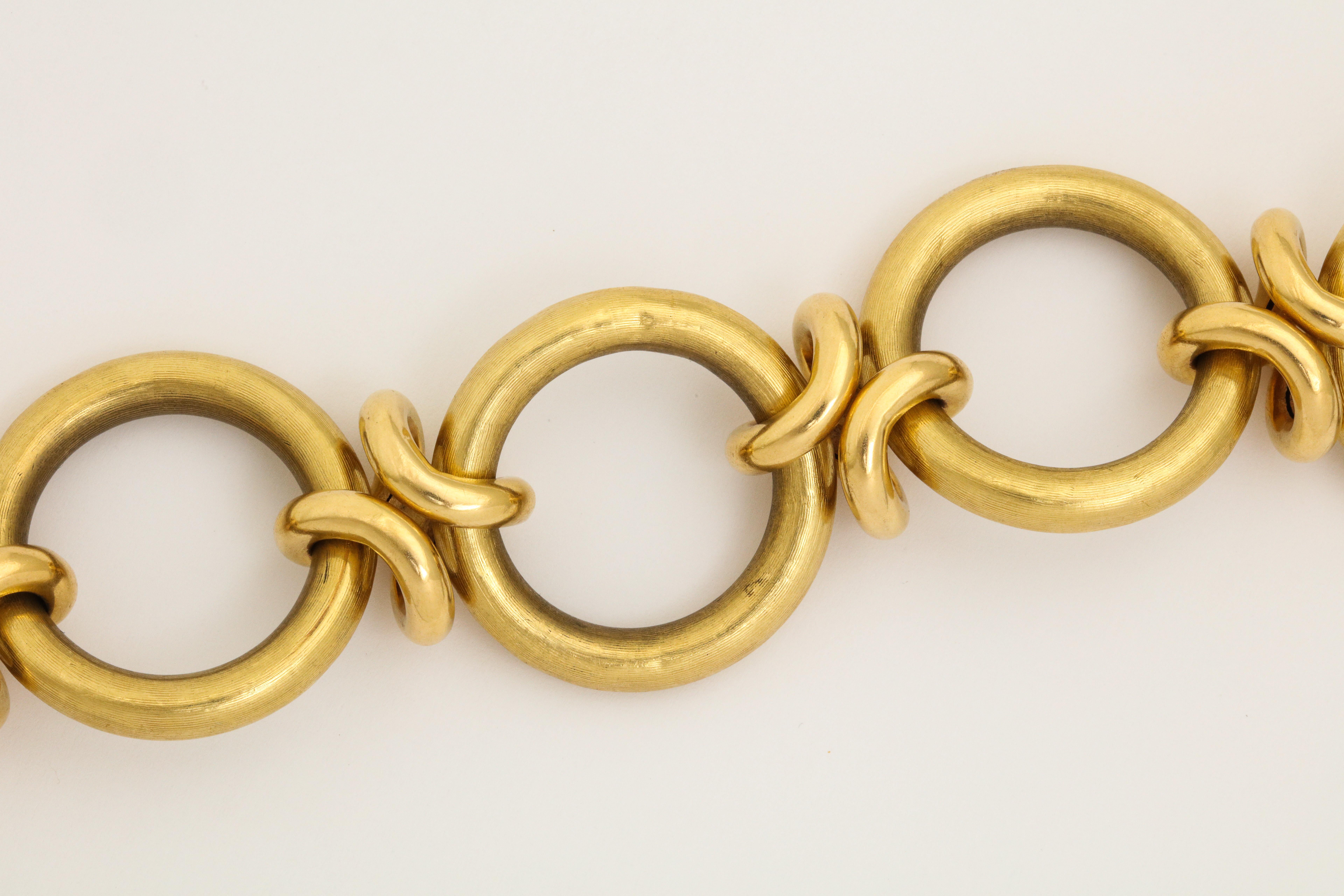 A great  18K Gold Circle Link Bracelet with Love Knots connecting the open circles.  The links have a textured matte  finish.  This is a day wearable, never take off piece of jewelry.