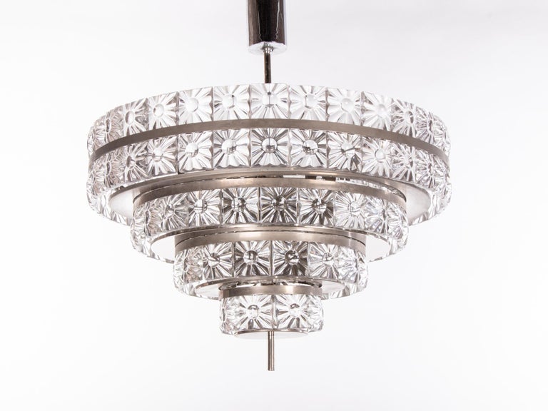 Stunning large five-tier chandelier with heavy crystal glass elements on a nickel frame. Crystal glasses resemble magnifying glasses. Chandelier illuminates beautifully and offers a lot of light. Gem from the time. With this light you make a clear
