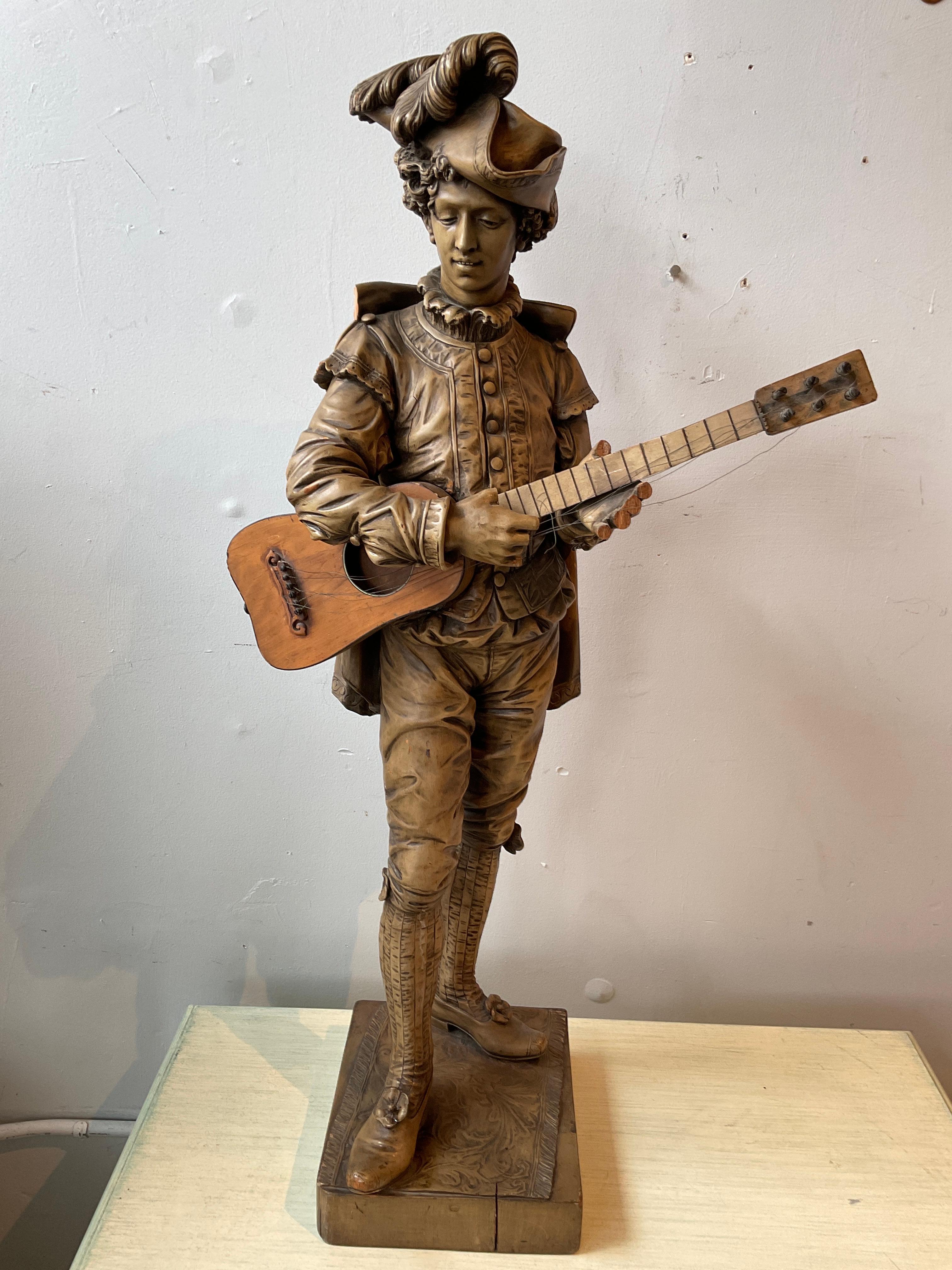 Large Italian 1880s carved wood figure of Figaro. Nicely carved. Fingers missing. Piece of collar missing. Strings on guitar need restringing.