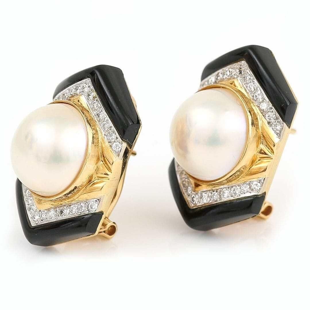 A large and fabulous pair of 18ct yellow gold and mabe pearl, diamond and onyx earrings by Trio. The central set mabe pearl of creamy, metallic hues measuring 13mm (diameter) is bordered by a double chevron of brilliant cut diamonds and a further