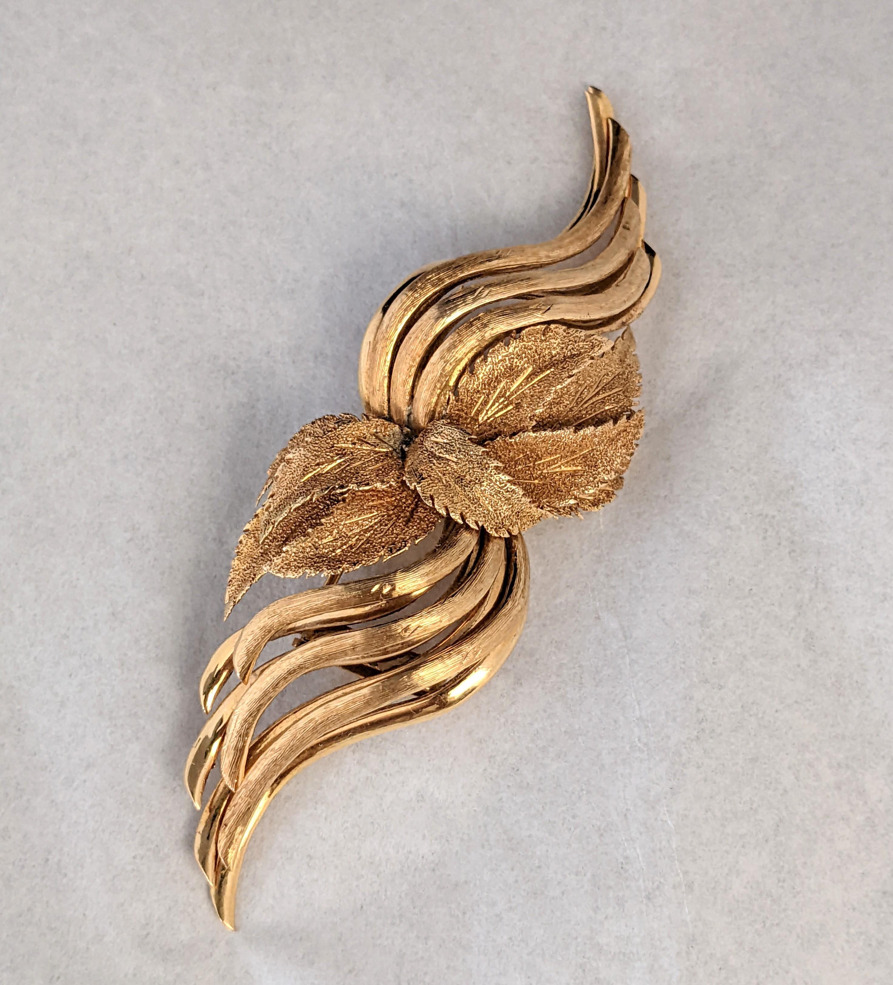 Large Leaf Ornamented Spray clip custom made in 18k gold. Large scale with central leaf cluster. There are both florentined and high polish sprays which emanate from the center to give the spray a dimensional feel like a pair of wings.  
1950's USA.