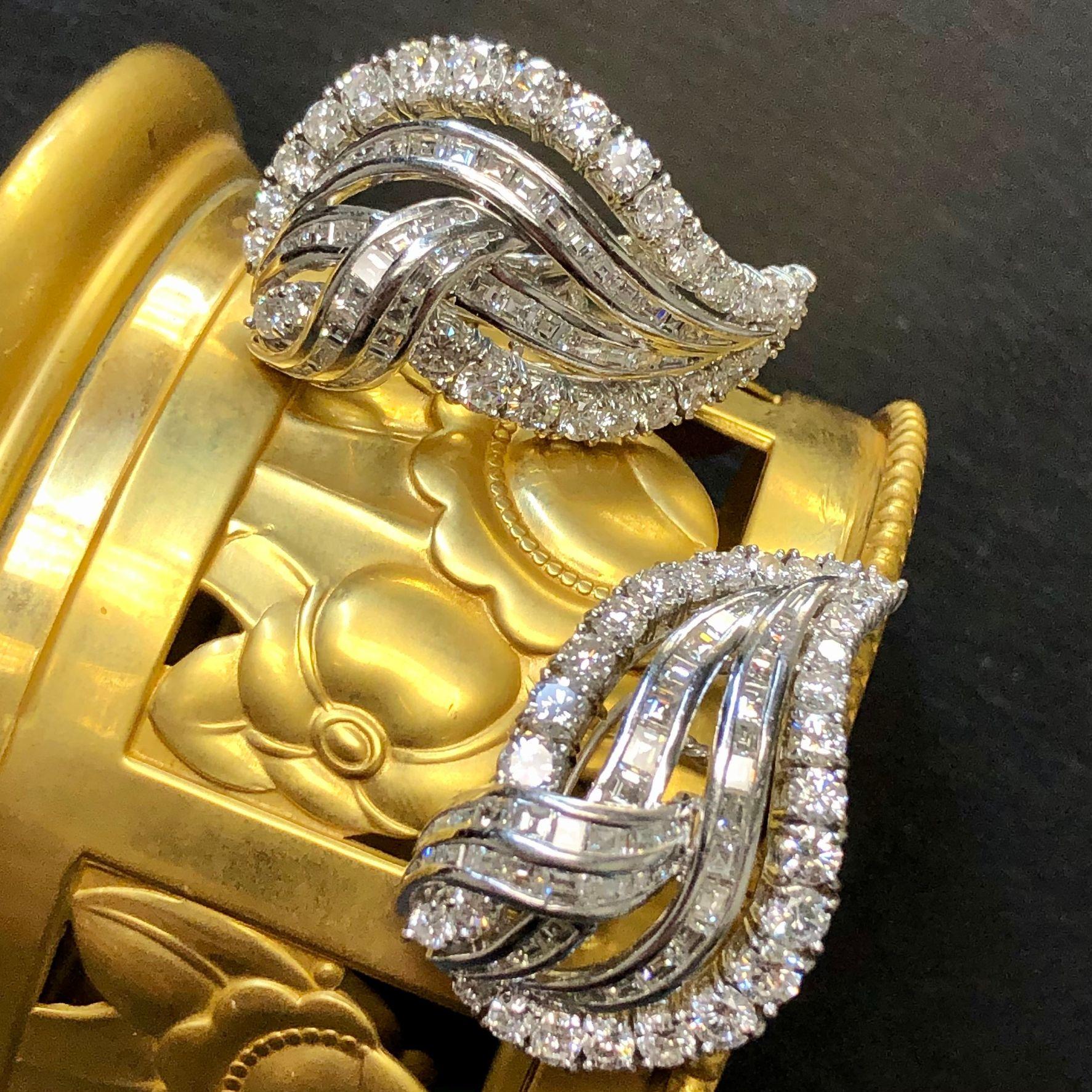 Une impressionnante paire de boucles d'oreilles en or blanc 18 carats, sertie d'environ 9 carats de gros diamants ronds et de diamants baguettes carrés et longs, pour un poids total approximatif de 9 carats, toutes les pierres étant de couleur G-H