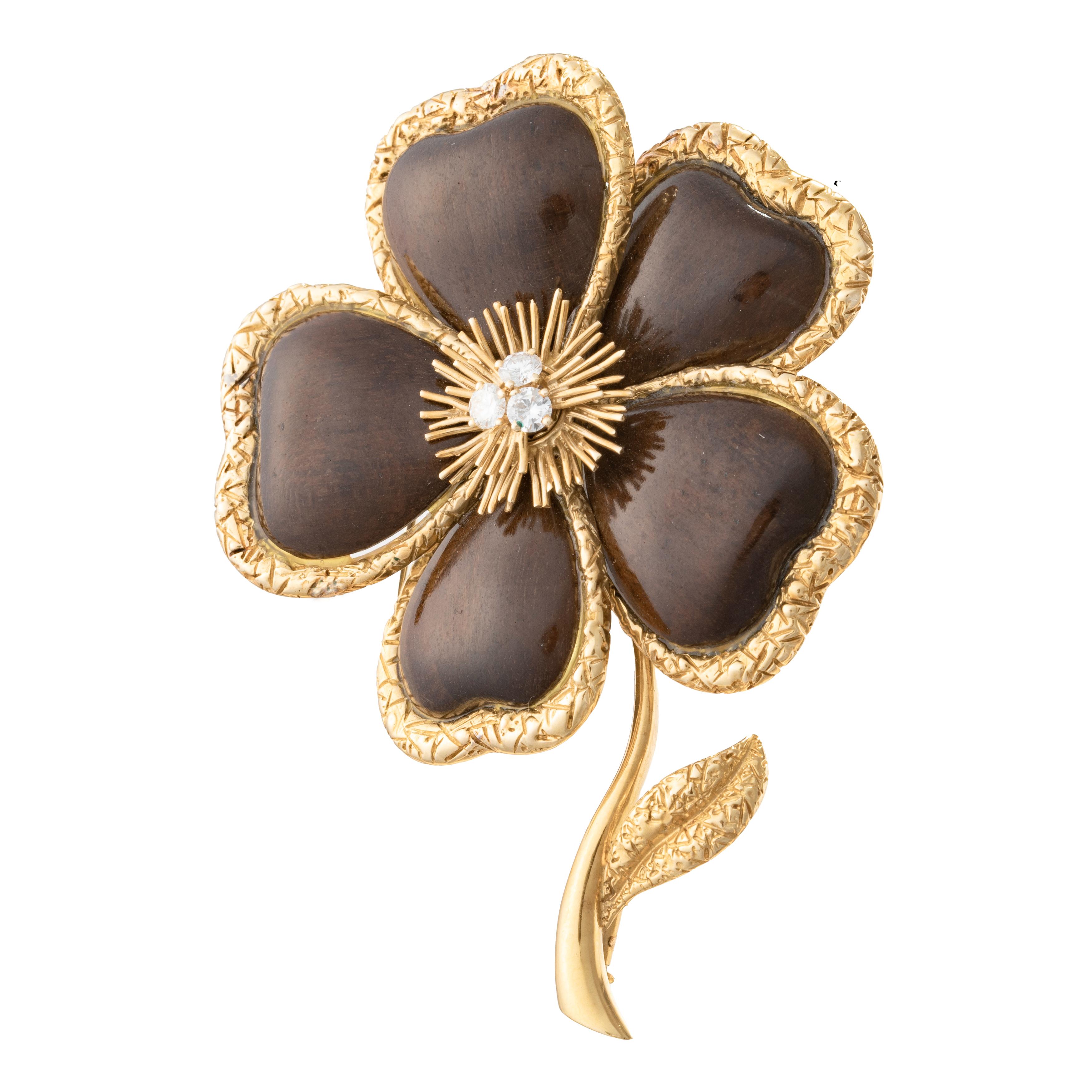 Van Cleef & Arpels large clematis flower brooch, the flowerhead centering three round brilliant-cut diamonds within a gold wire spray surrounded by five carved wood petals each within a hammered gold frame.  The flowerhead sprouting from a polished