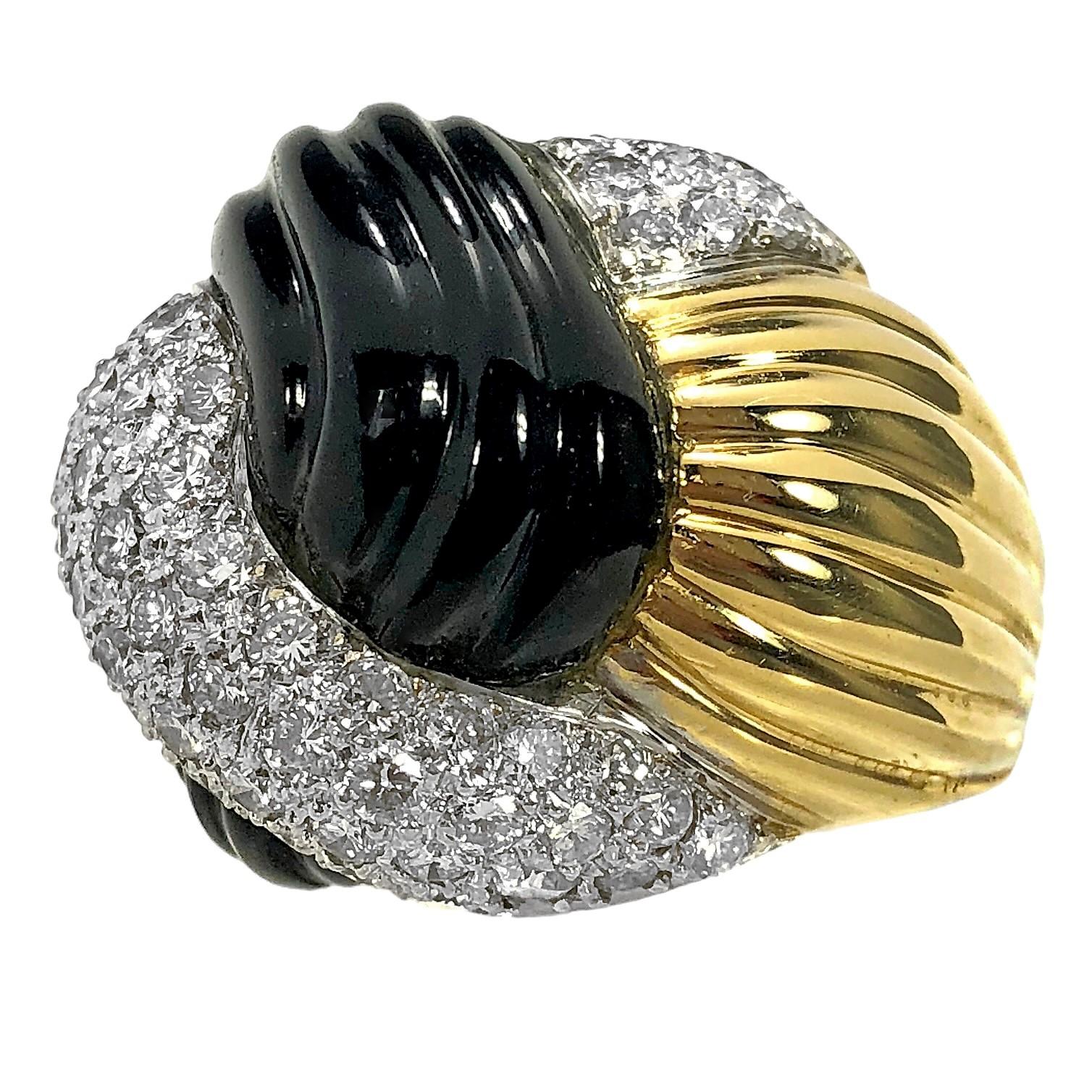 Cette bague de cocktail en or jaune 18 carats pour femme de la fin du XXe siècle est conçue comme un grand nœud remarquable. Le contraste des diamants blancs brillants sertis dans des plaques de rhodium juxtaposées aux surfaces cannelées, en onyx et