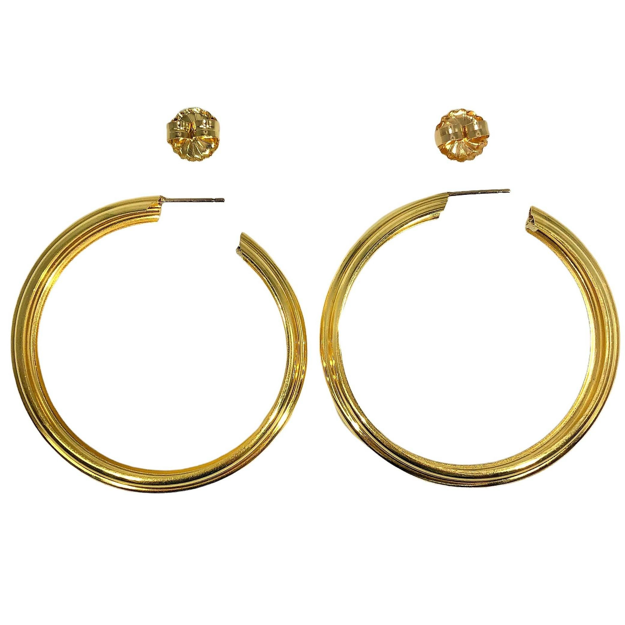 Lightweight yet sturdy, this unique pair of 18k yellow gold Italian hoop earrings is quite large, measuring a full 2 inches in diameter by 3/8 inch wide. The fluted design sets these apart from other styles of hoop earrings. The hoops are 18K gold