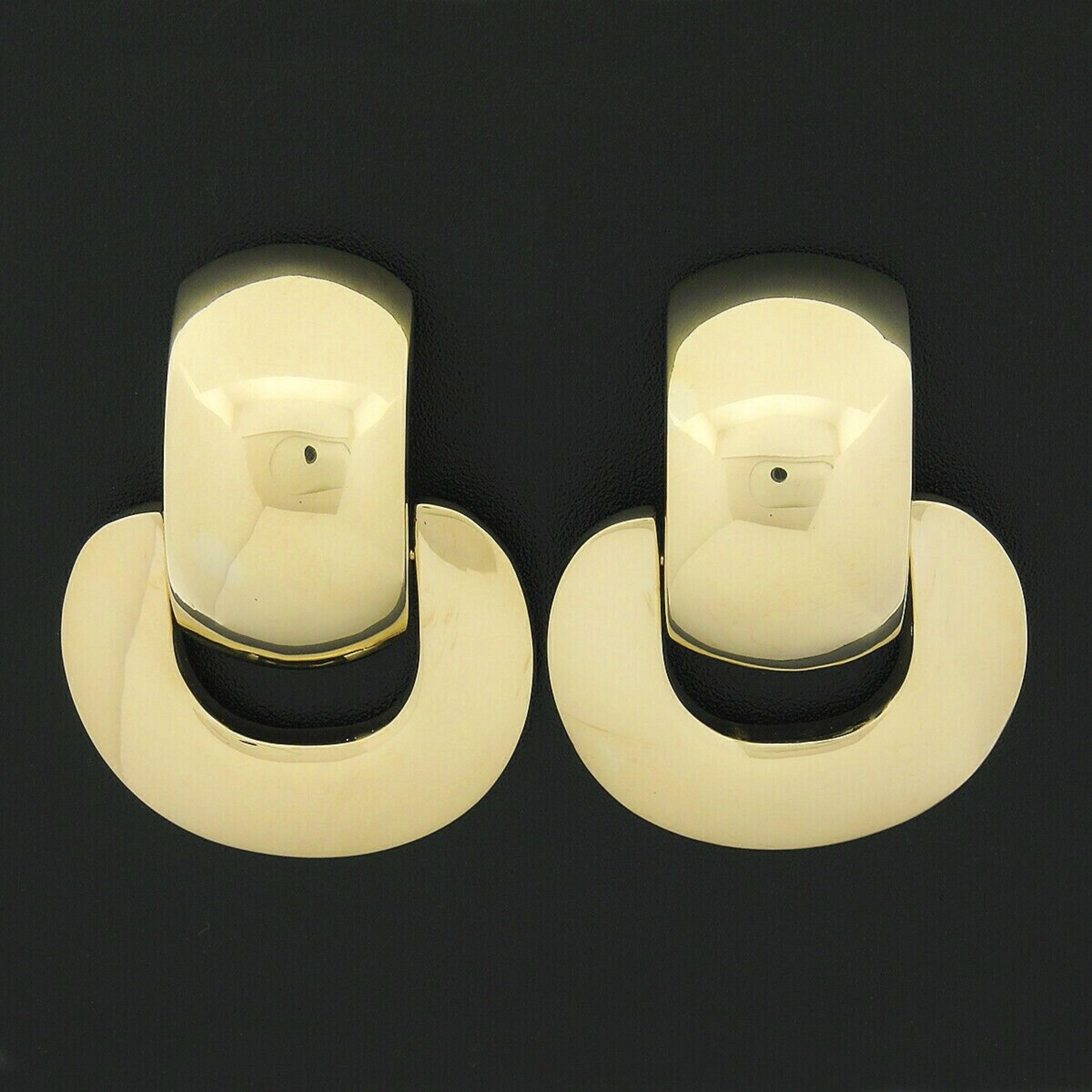 These outstanding statement earrings are crafted in solid 18k yellow gold and feature a large door knocker design with wonderful high polished finish throughout, giving them their super shiny and attractive appearance. The bottom portion elegantly