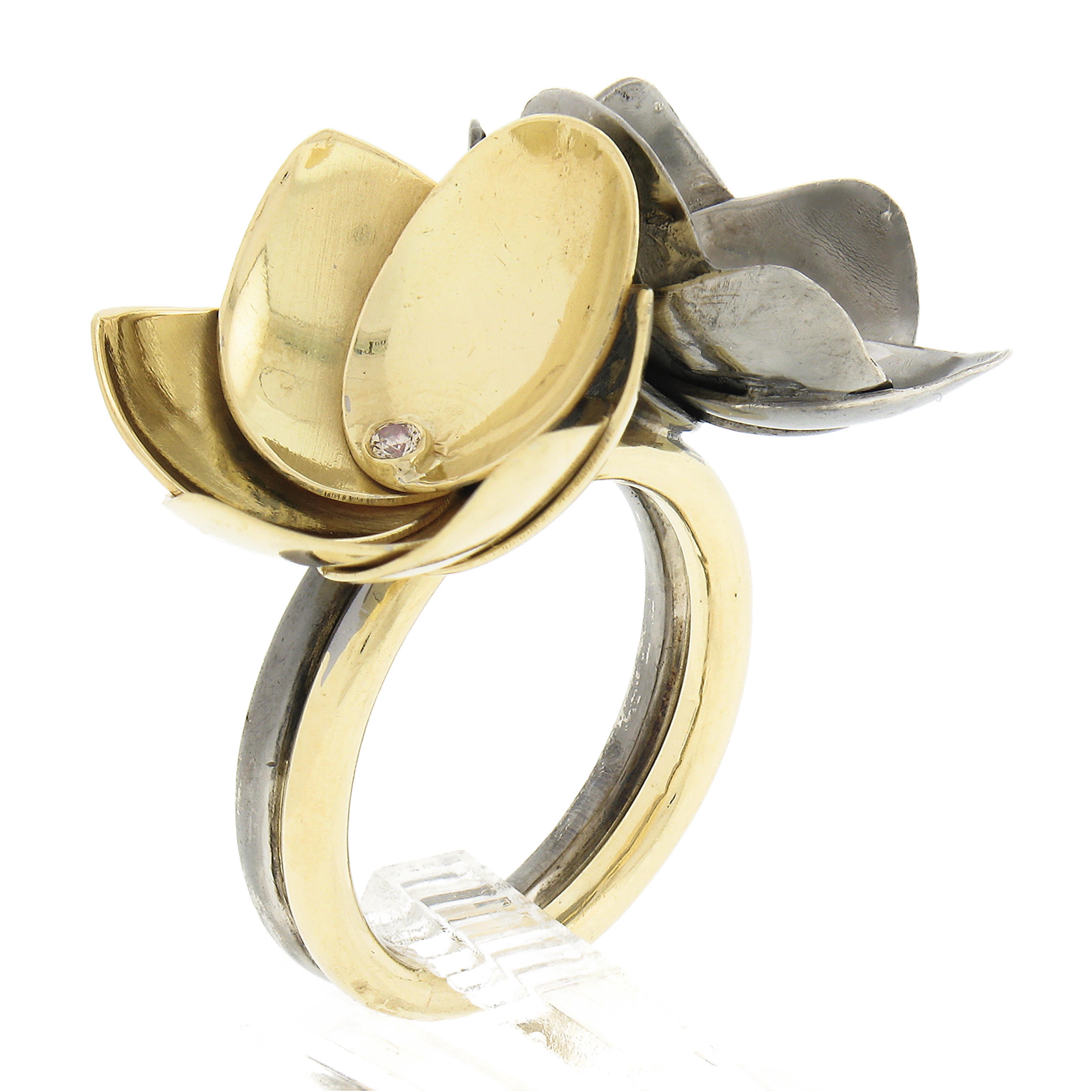 Here we have a gorgeous handmade cocktail ring crafted in solid 18k yellow gold & silver. The ring features twin beautiful layered flowers that are neatly set with 2 round brilliant cut diamonds at each flower's center. The ring has a polished