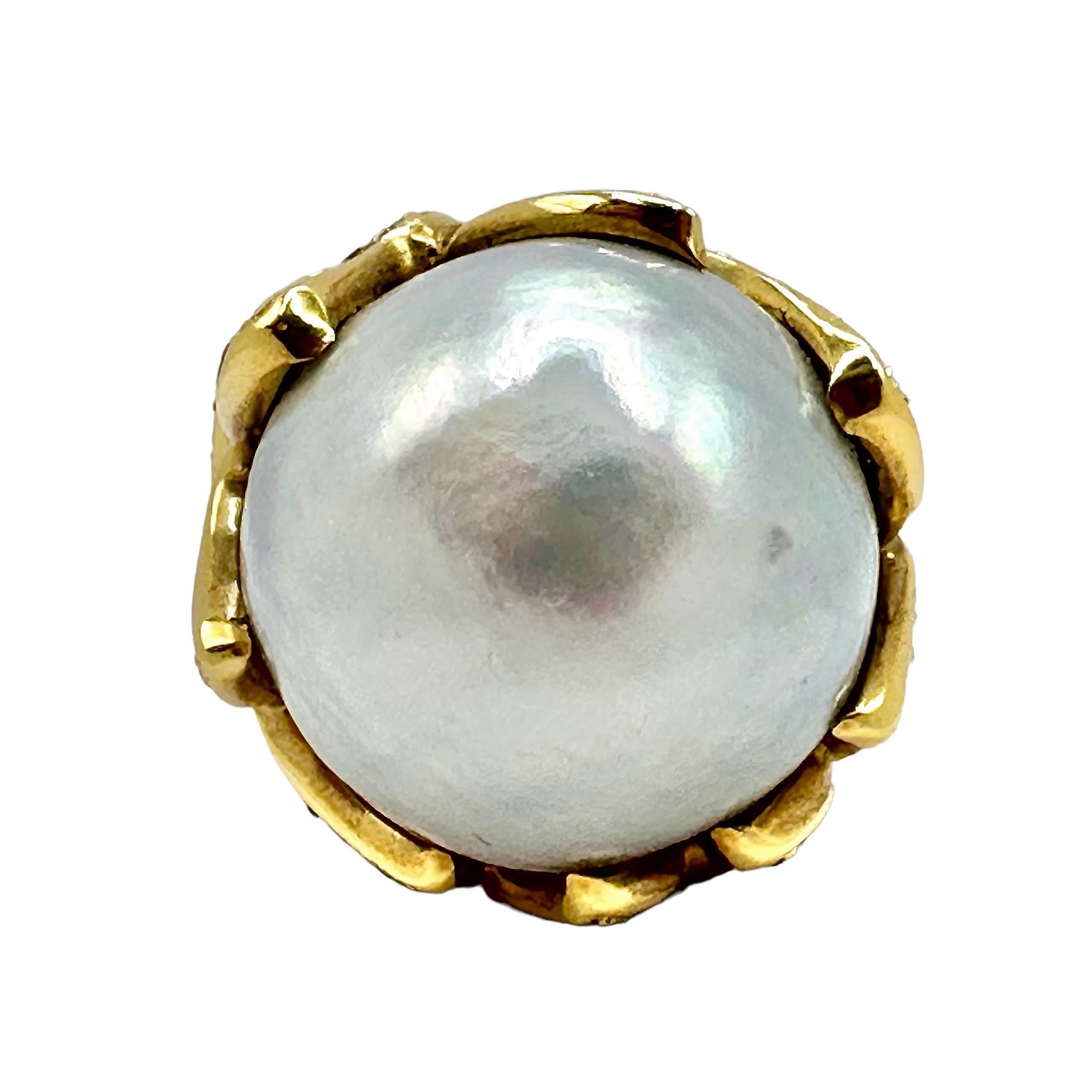 This very large Late-20th Century ladies fashion ring is crafted in 18K yellow gold with an enormous 19mm South Sea cultured pearl at it's center.
The pearl is surrounded and secured by eight flame pattern inspired prongs, all a part of the