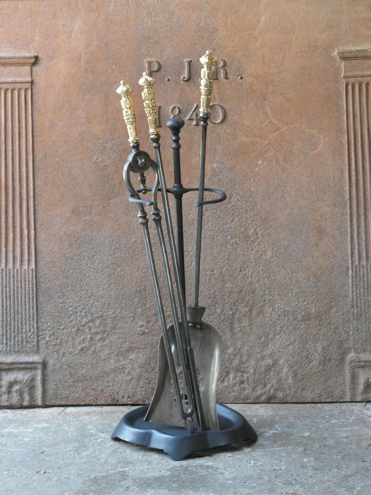 Beautiful 18th - 19th century English Georgian fireplace tool set. The tool set consists of tongs, shovel, poker and stand. The stand is made of wrought iron and the tools are made of wrought iron with polished brass handles. The set is in a good