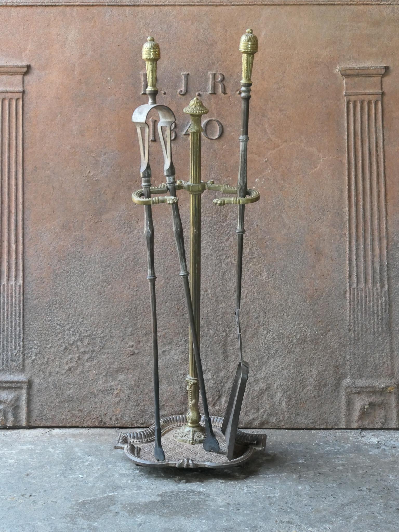 Beautiful 18th - 19th century French neoclassical fireplace tool set. The tool set consists of tongs, shovel and stand. The stand is made of cast iron and brass and the tools are made of wrought iron and brass. The set is in a good condition and fit
