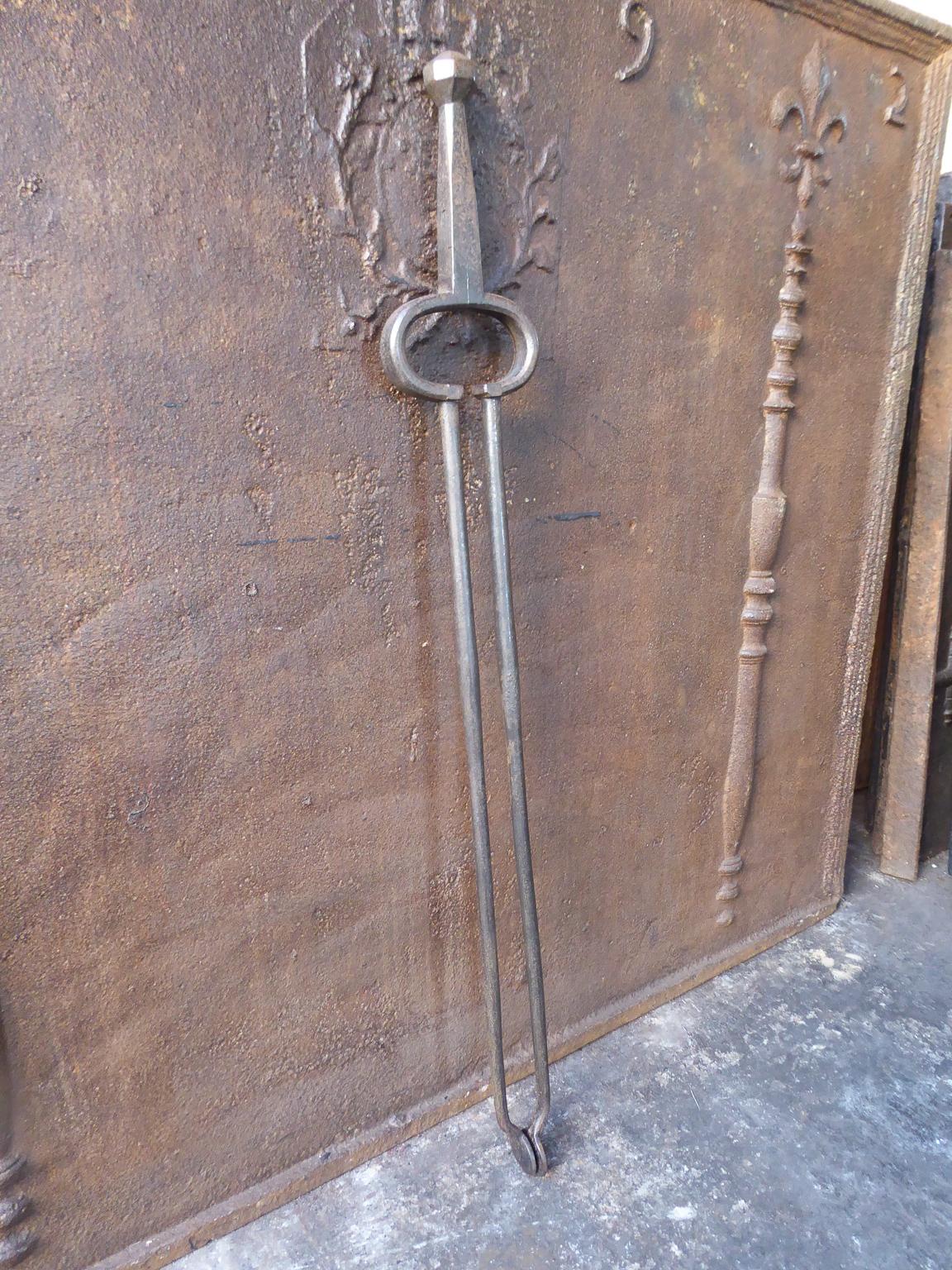 18th-19th century Dutch fireplace tongs made of wrought iron. With 33.5 inch (85 cm) height, this is a large pair.