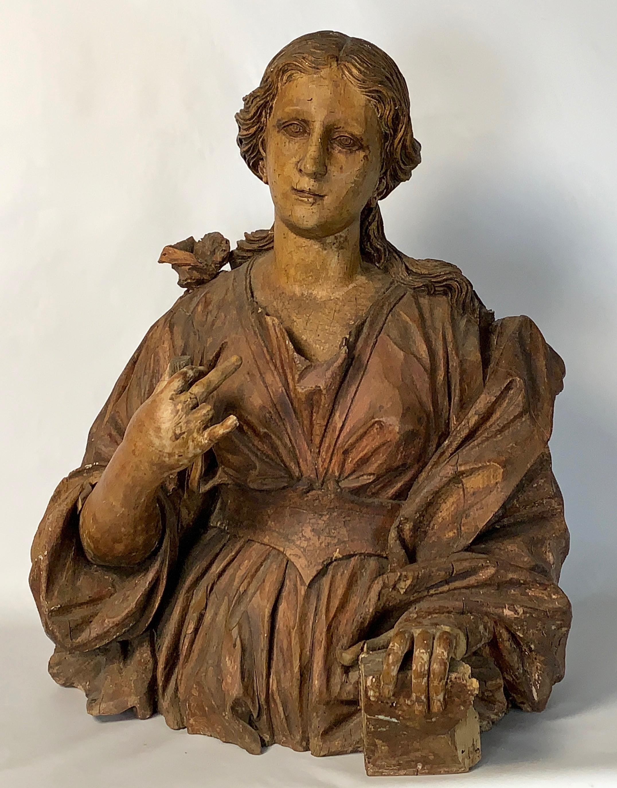 An exceptional mid-18th century life-sized Italian carved wooden bust of a beautiful young woman with traces of original paint.