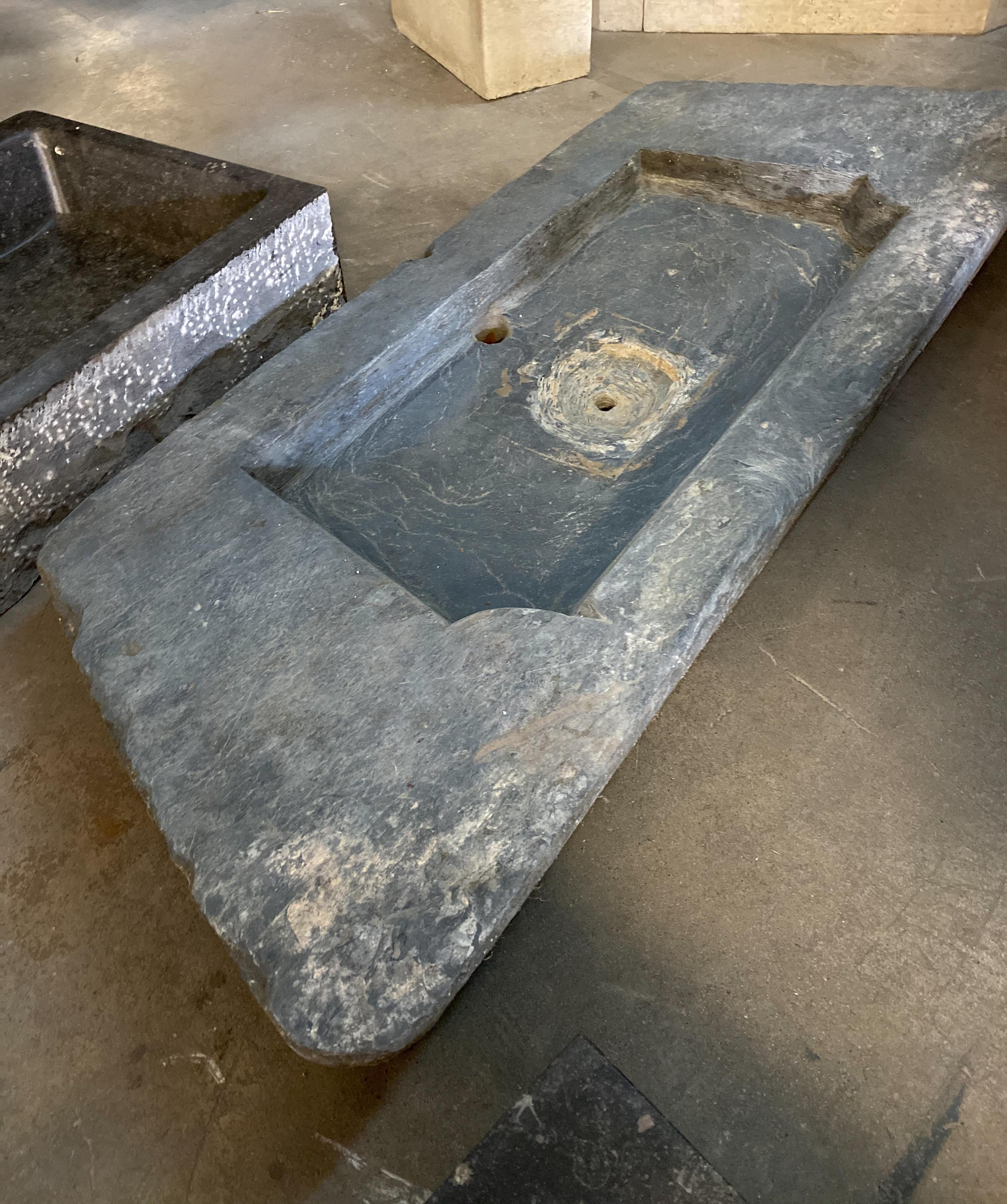 This large bluestone sink originates from Belgium, circa 1780.

The drain hole can be drilled as needed and bottom of basin smoothed out before shipping. First photo shows version smoothed out, photos following shows previous drain