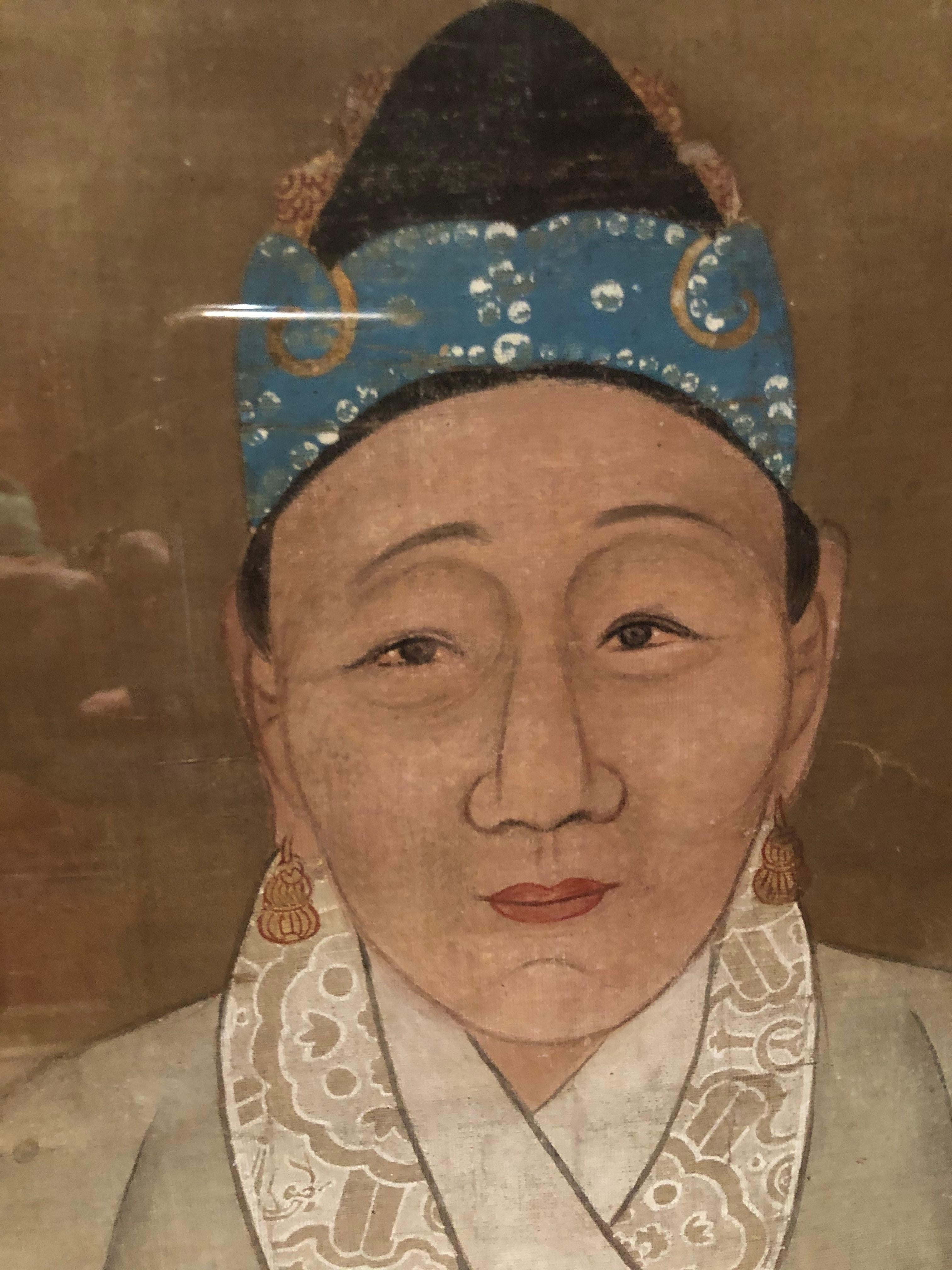 Chinese ancestral portrait painted on silk having beautiful details and soft colors dating to the mid-18th century. The frame is a simple black wooden molding. There are a few brown spots that are very small and probably the result from old