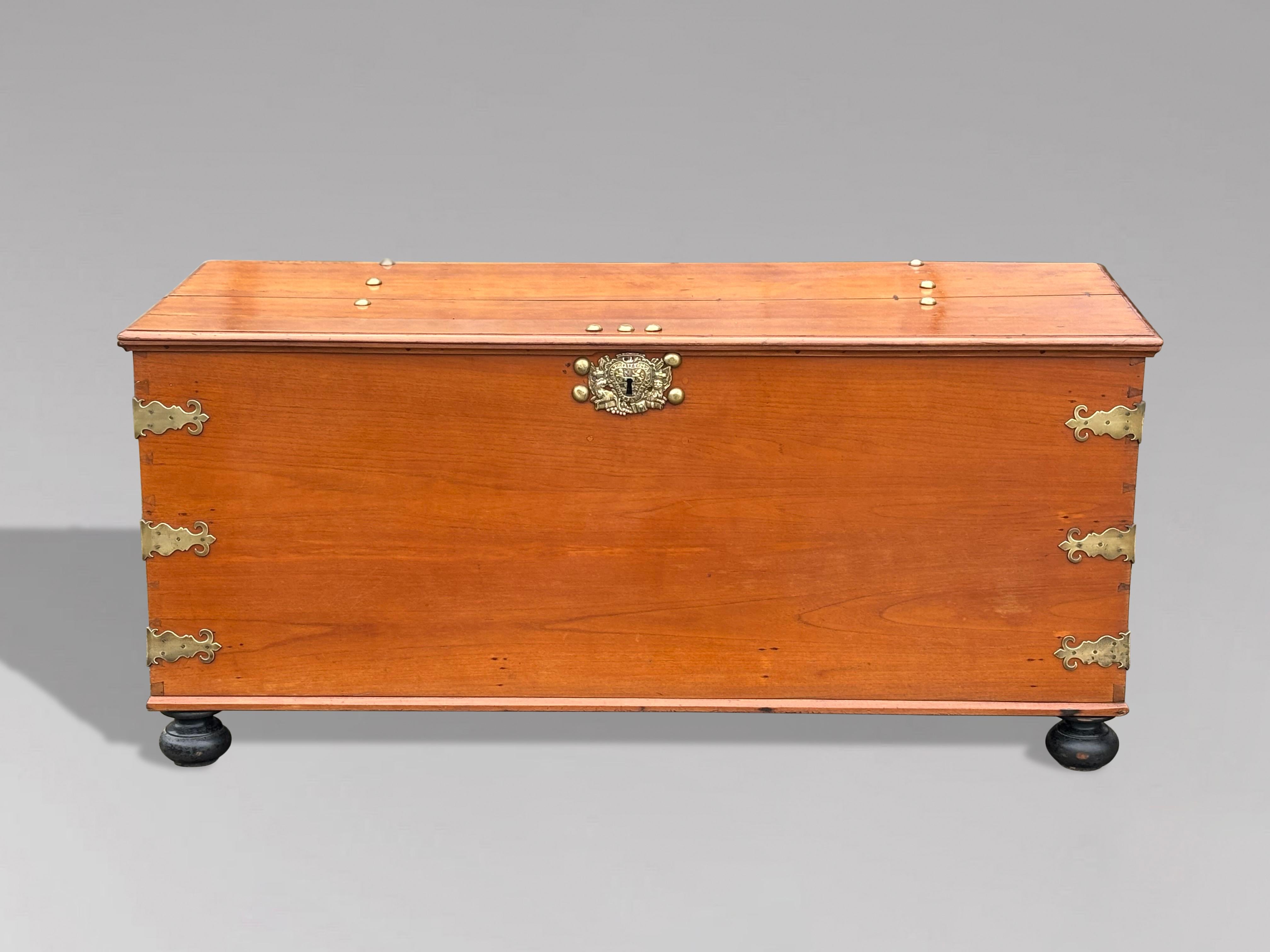 This impressive 18th-century walnut colonial coffer, also known as a blanket chest, features exceptional brass hardware and is constructed from solid pieces of walnut. The chest is designed with a hinged rectangular moulded lid that opens to reveal