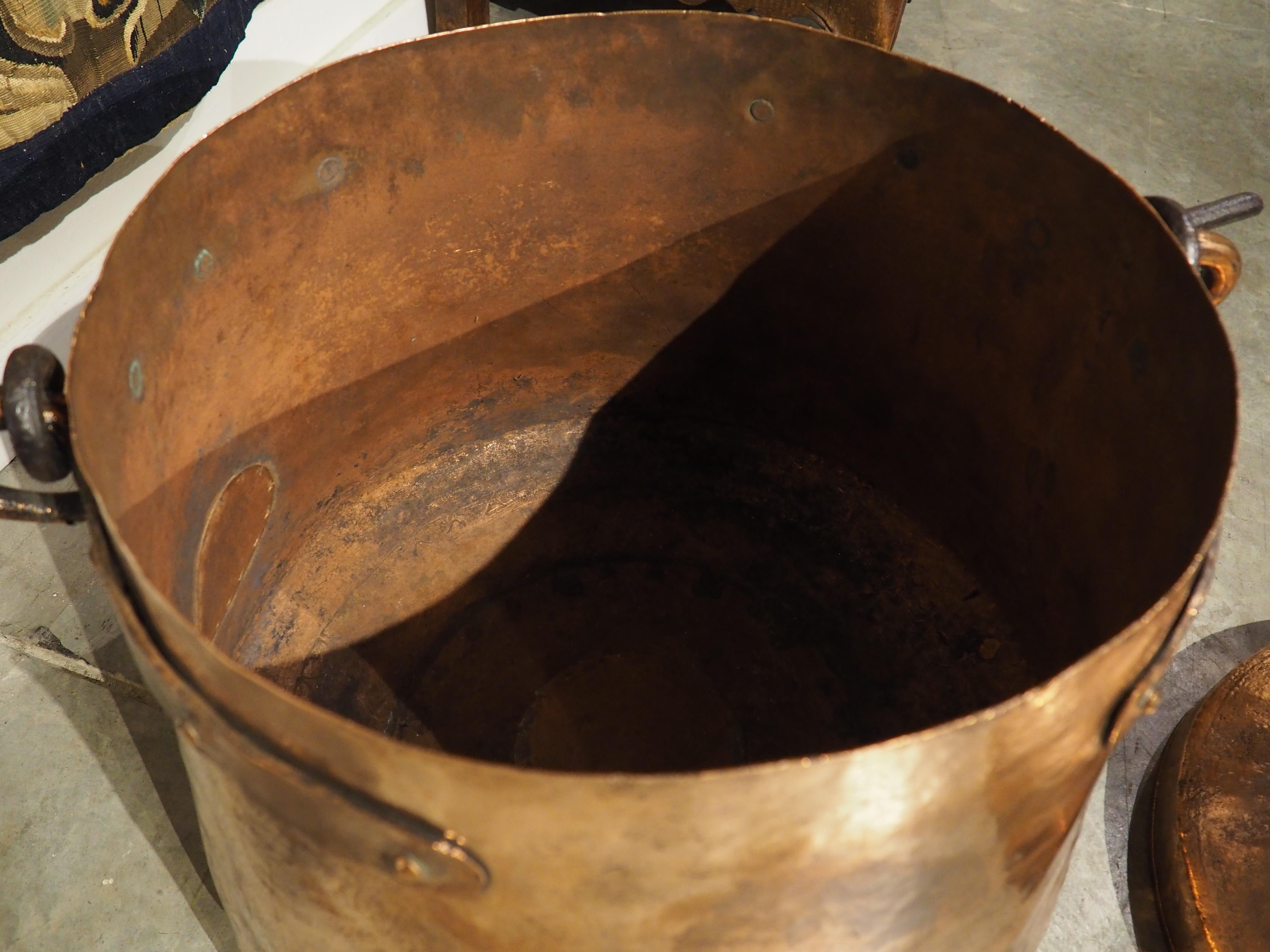 Dieses große, in Frankreich handgefertigte Chaudron aus Kupfer und Schmiedeeisen wurde ursprünglich um 1700 zum Kochen von Mahlzeiten über dem Feuer verwendet. Der eiserne Henkel wurde an einem Kaminhaken befestigt, an dem der Kessel über den