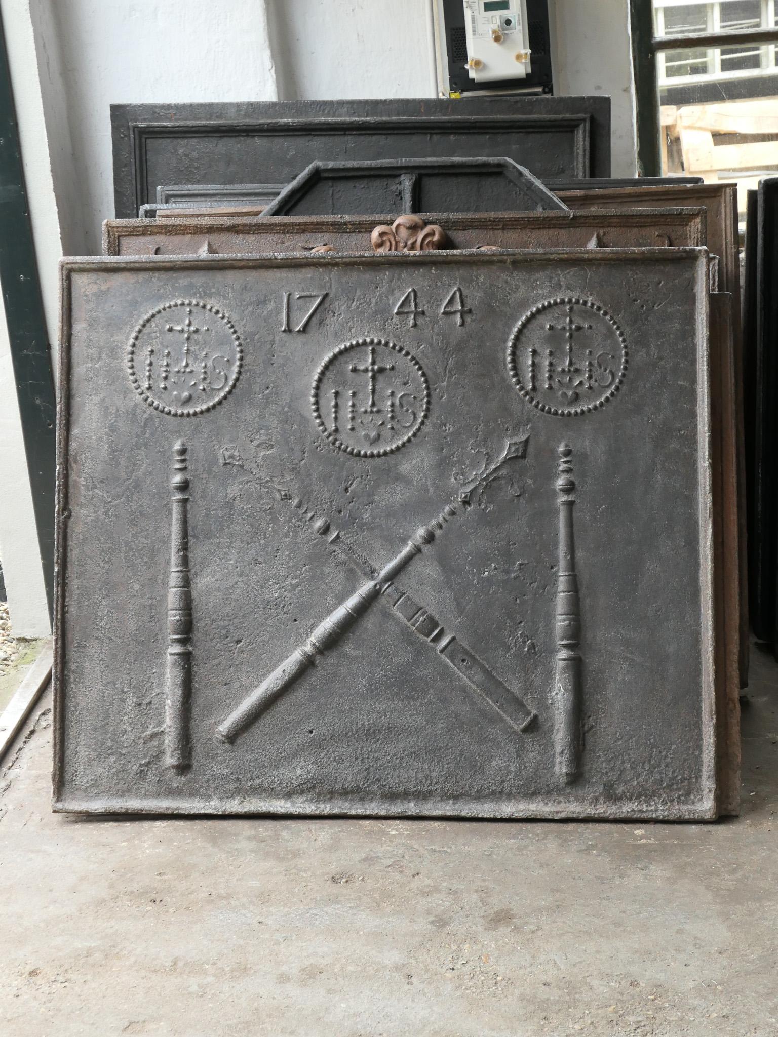 Large 18th century French Louis XIV fireback with two pillars, a IHS monogram and the date of production 1744.

The monogram IHS stands for Iesus Hominum Salvator (Jesus the Savior of Humanity) or In Hoc Signo (In this sign will you win). The
