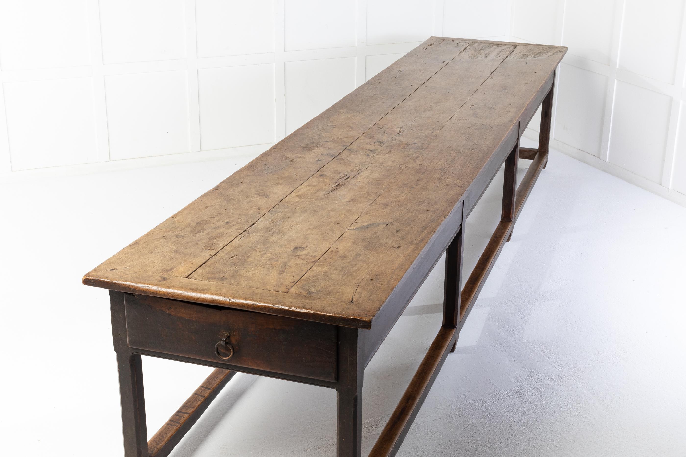 This monumental French 18th century table is over four metres long. An outstanding table retaining its original paint colour on the base and original sun bleached top. Having a single drawer at one end with its original handle. Four leg supports to
