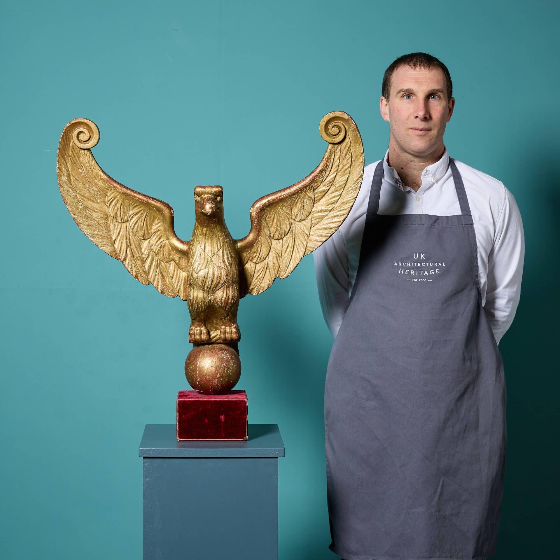A large early 18th century carved gilt wood eagle, mounted on a square red velvet covered plinth.

Originally used as a lectern adornment, this architectural eagle ornament is deeply carved with details of the eagle with wings outspread still clear
