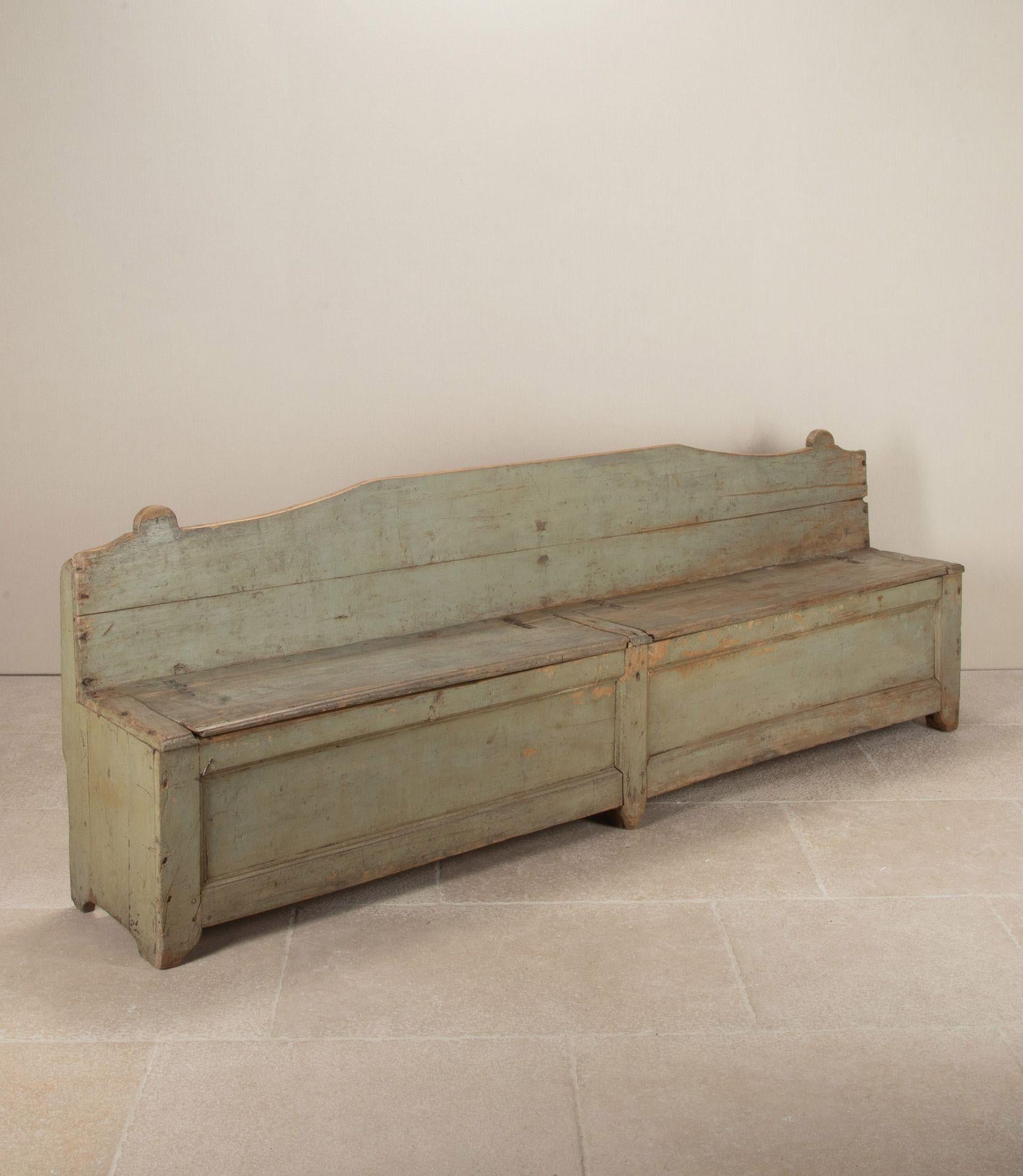Banco o asiento italiano de finales del siglo XVIII con pátina original pintada de color gris pálido pastel. Con dos asientos abatibles para guardar objetos.
