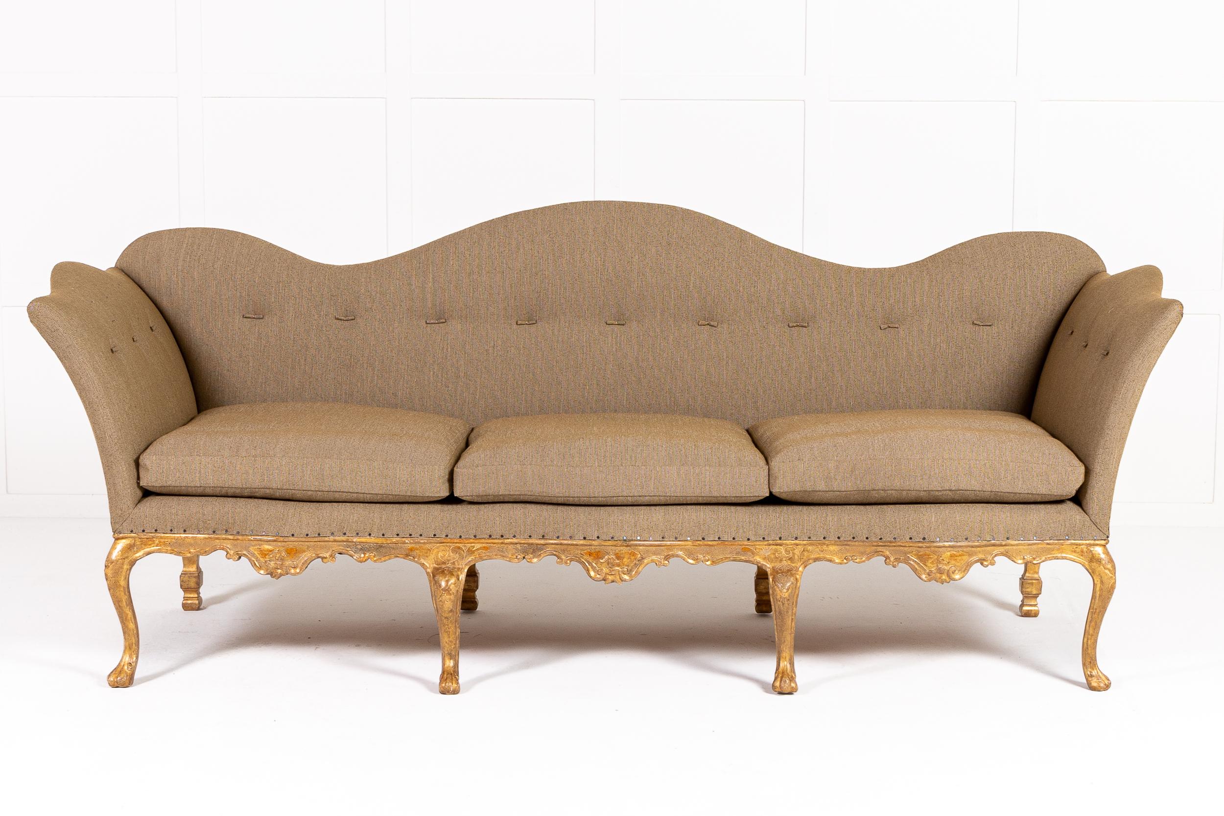 Canapé en bois doré rococo italien du XVIIIe siècle d'une taille particulièrement importante.

Avec ses supports de dossier et d'accoudoir en forme de nuage et son tablier ondulant et serpentin, cette pièce incarne l'élégance du design rococo