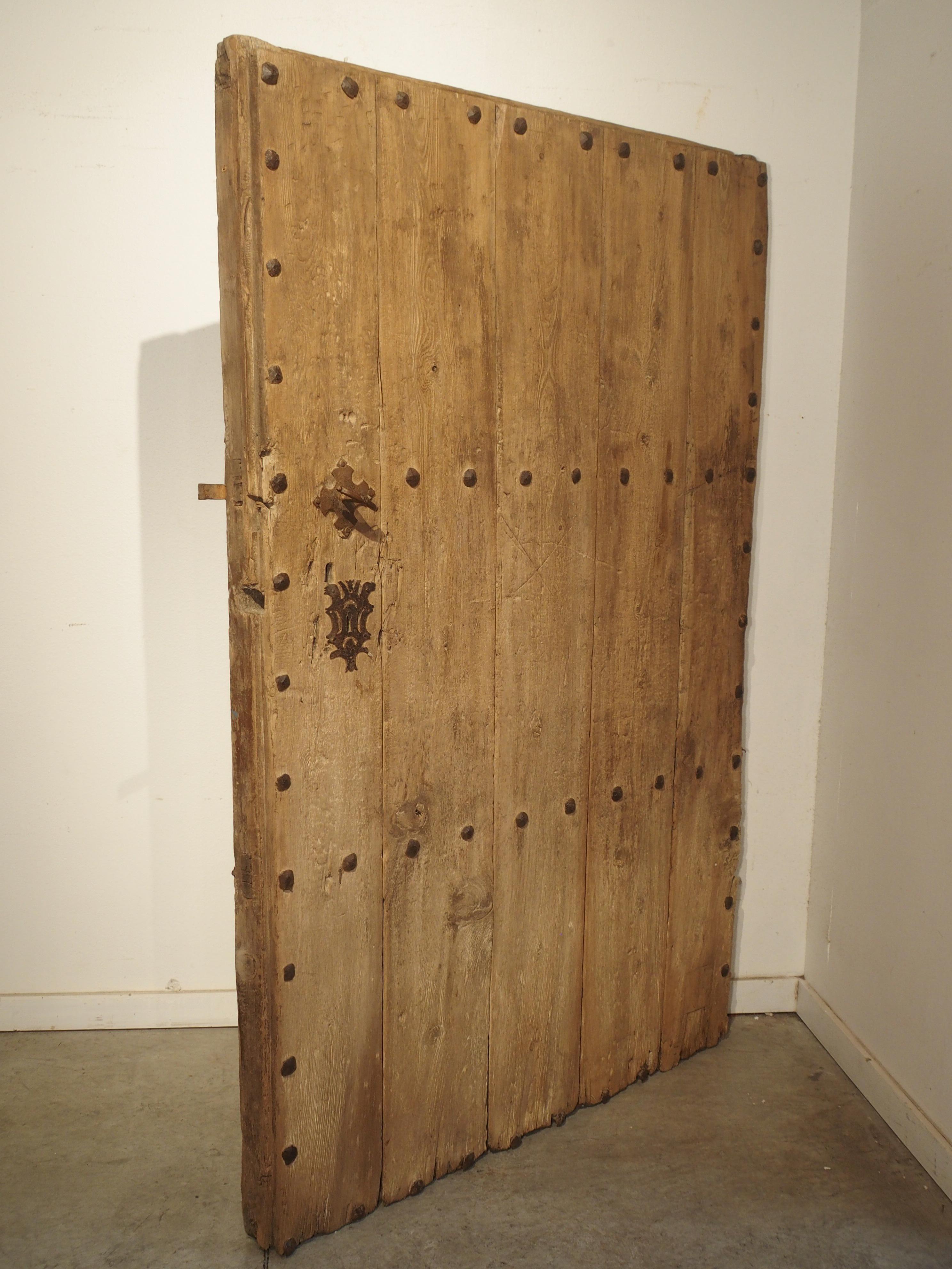 This unique Spanish door is from the 1700’s and has been adorned with wrought iron nailheads. The front of the door consists of five thick oak planks that have been constructed using mortise and tenon joints (as seen on the sides). Four horizontal