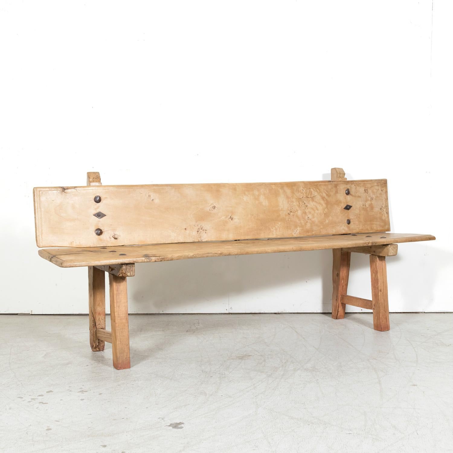 A large 18th century primitive bench from the Catalan region of Spain, circa 1780s. Handcrafted from mélèze, a robust pine variety native to mountainous areas, its construction speaks to the skill and craftsmanship of its time. This antique Spanish