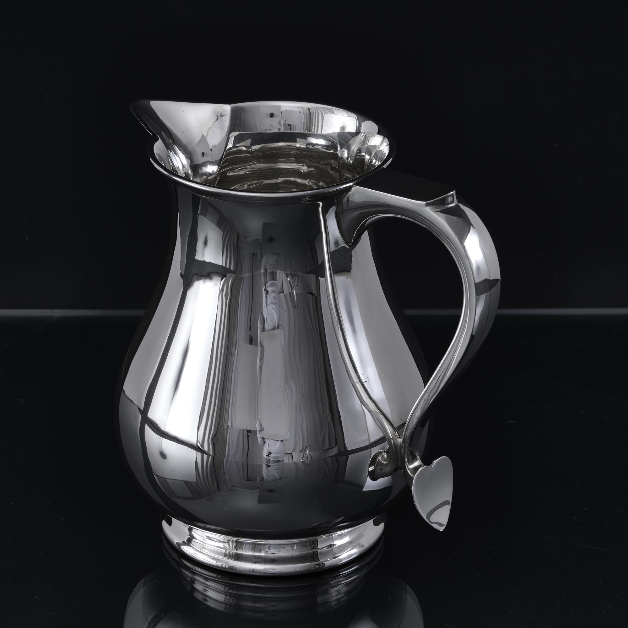 20th century sterling silver water jug in a classic 18th century style. This pleasing bellied form was first made popular in the early 1700s and was originally made to hold and serve beer, given that beer was much safer to drink than water at that