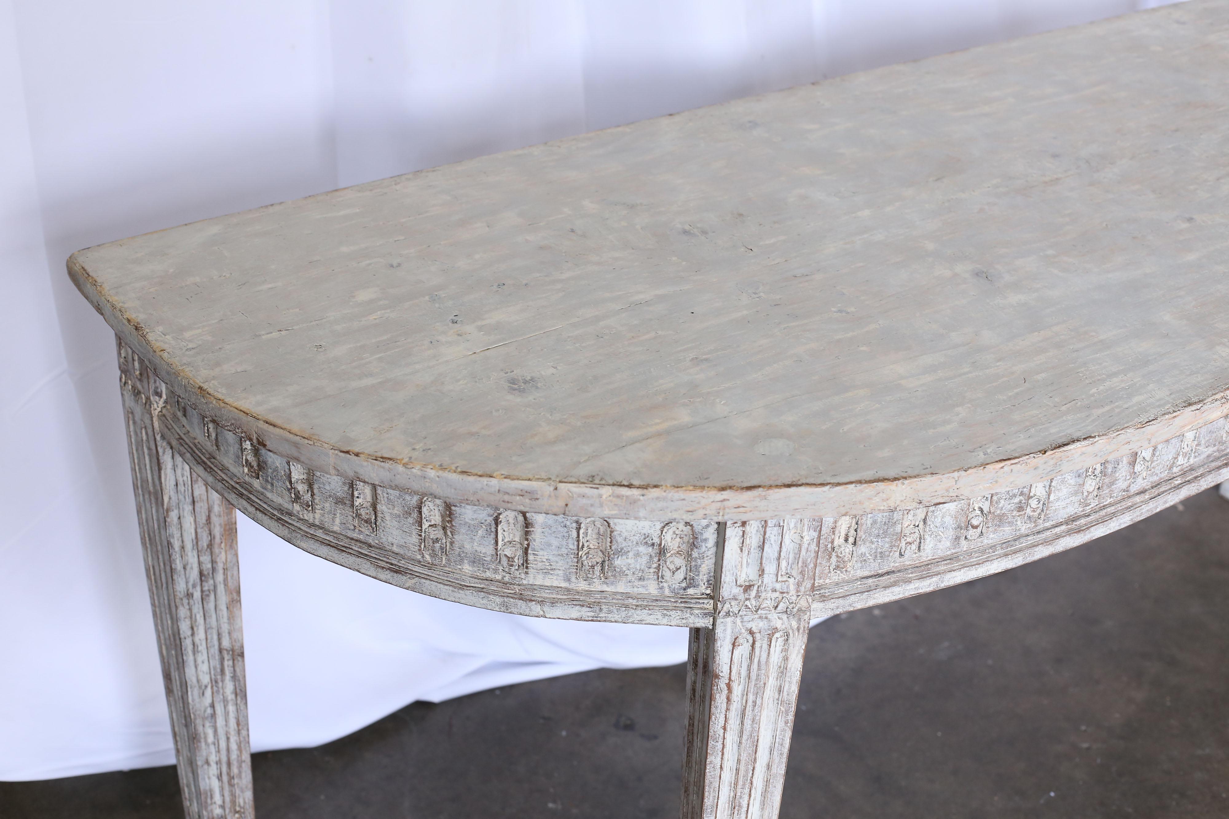 Large 19th century Swedish console or serving table. Table has four legs with a carved detail above each one and a carved detail surrounding the apron. The original paint has been dry-scraped.