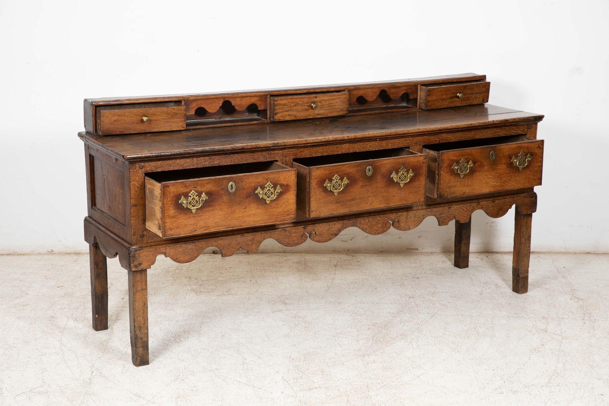 Circa 1760
Large 18thC Welsh Oak Vernacular Dresser Base. Three drawers on square legs with shaped apron and an arrangement of drawers.
Exceptional patination and colour.
sku 1070
W190 x D50 x H94 cm