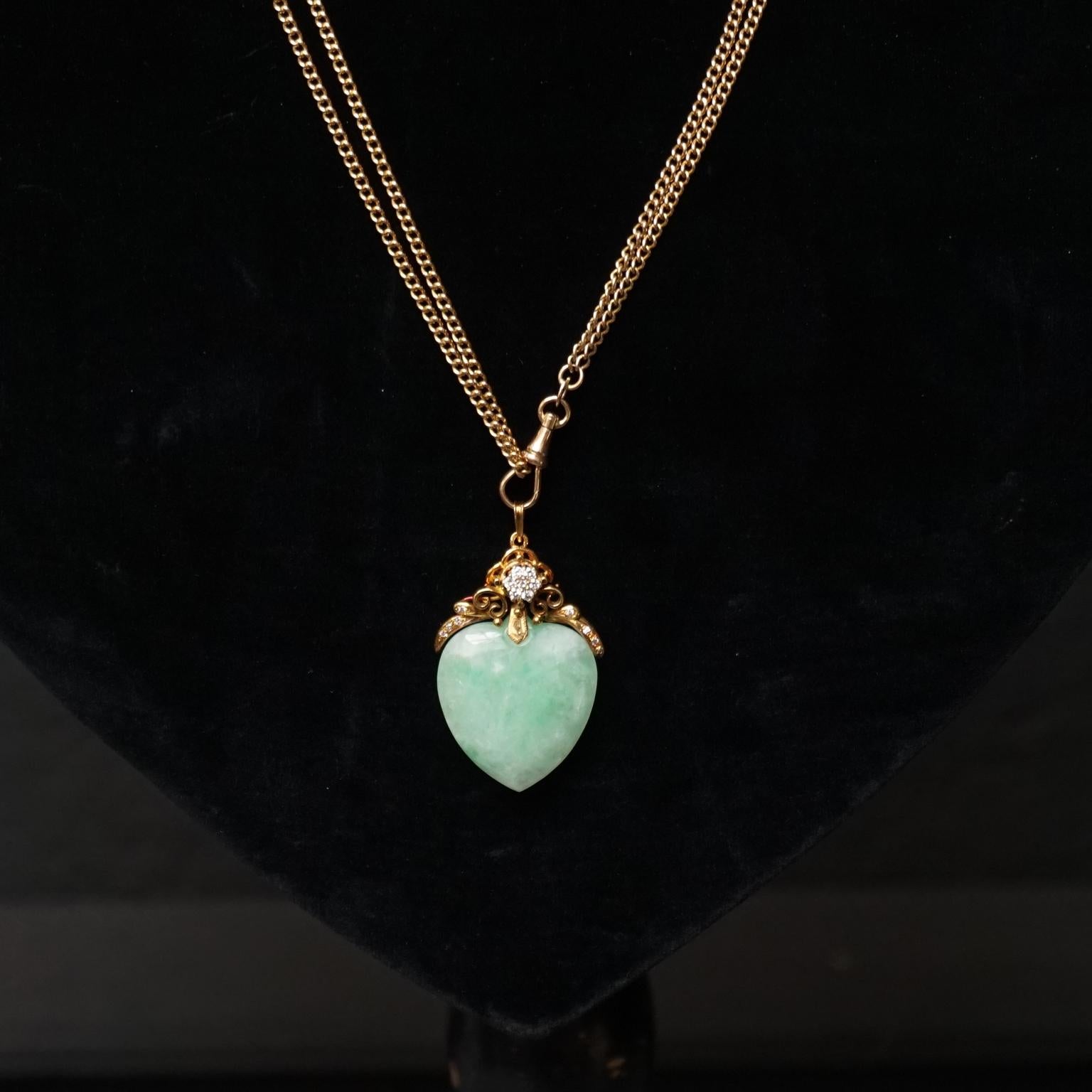 Beautiful 18-carat. Gold pendant fitted with and large hand carved ice green blushed Jade Jadeite heart. 
The hand forged gold curled parts are fitted with little brilliants, 4 left and 4 on the right side. In the middle six larger brilliant cut