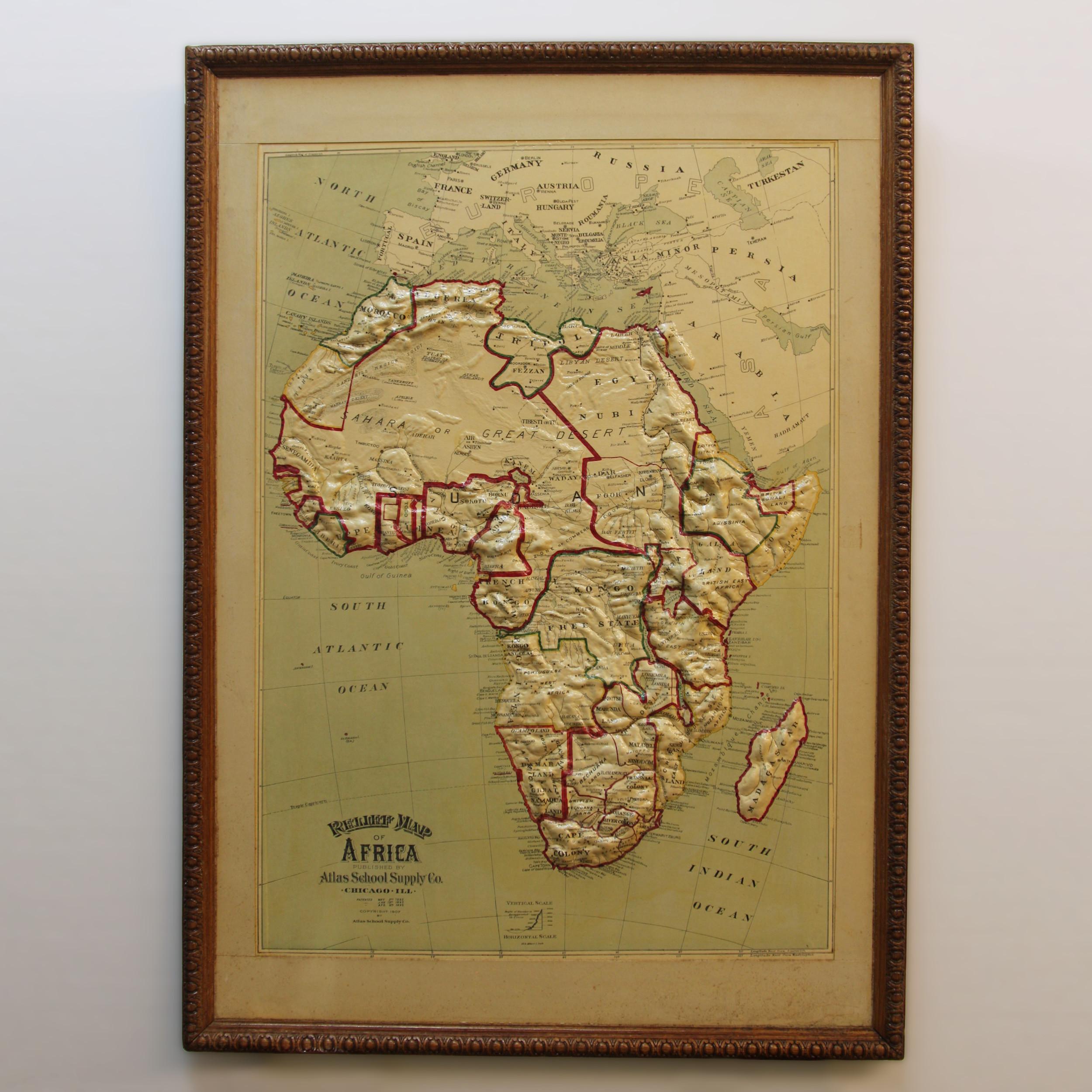 Remarkably original, 1907 Relief map of Africa by the Atlas School Supply Co. of Chicago, Illinois. This exceptional quality map features its original oak frame, heavy-duty stretcher, bold graphics and beautifully molded 3-D papier-mâché topography.