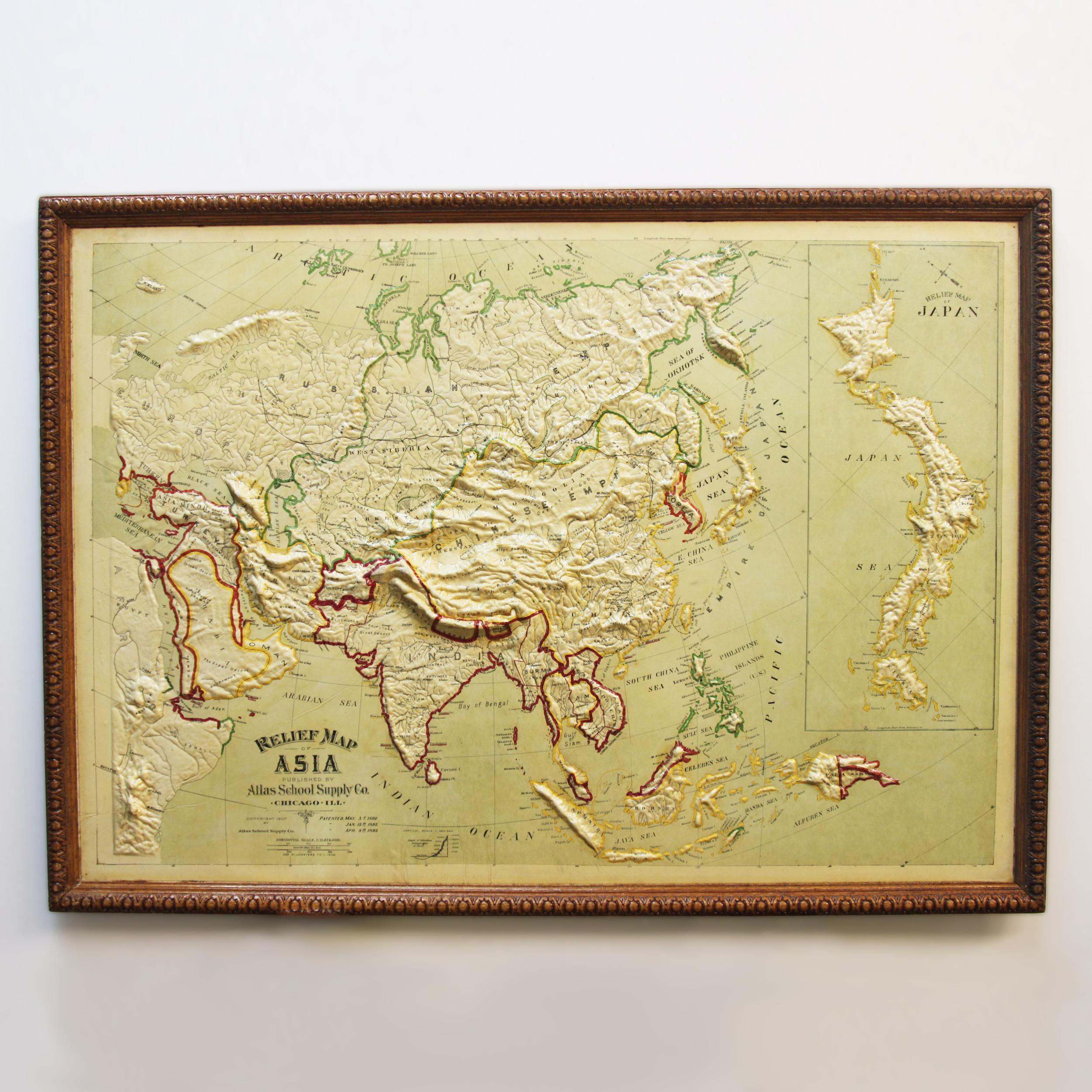 Remarkably original, 1907 Relief map of Asia by the Atlas School Supply Co. of Chicago, Illinois. This is an exceptional quality map features its original oak frame, heavy-duty stretcher, bold graphics and beautifully molded 3-D papier-mâché