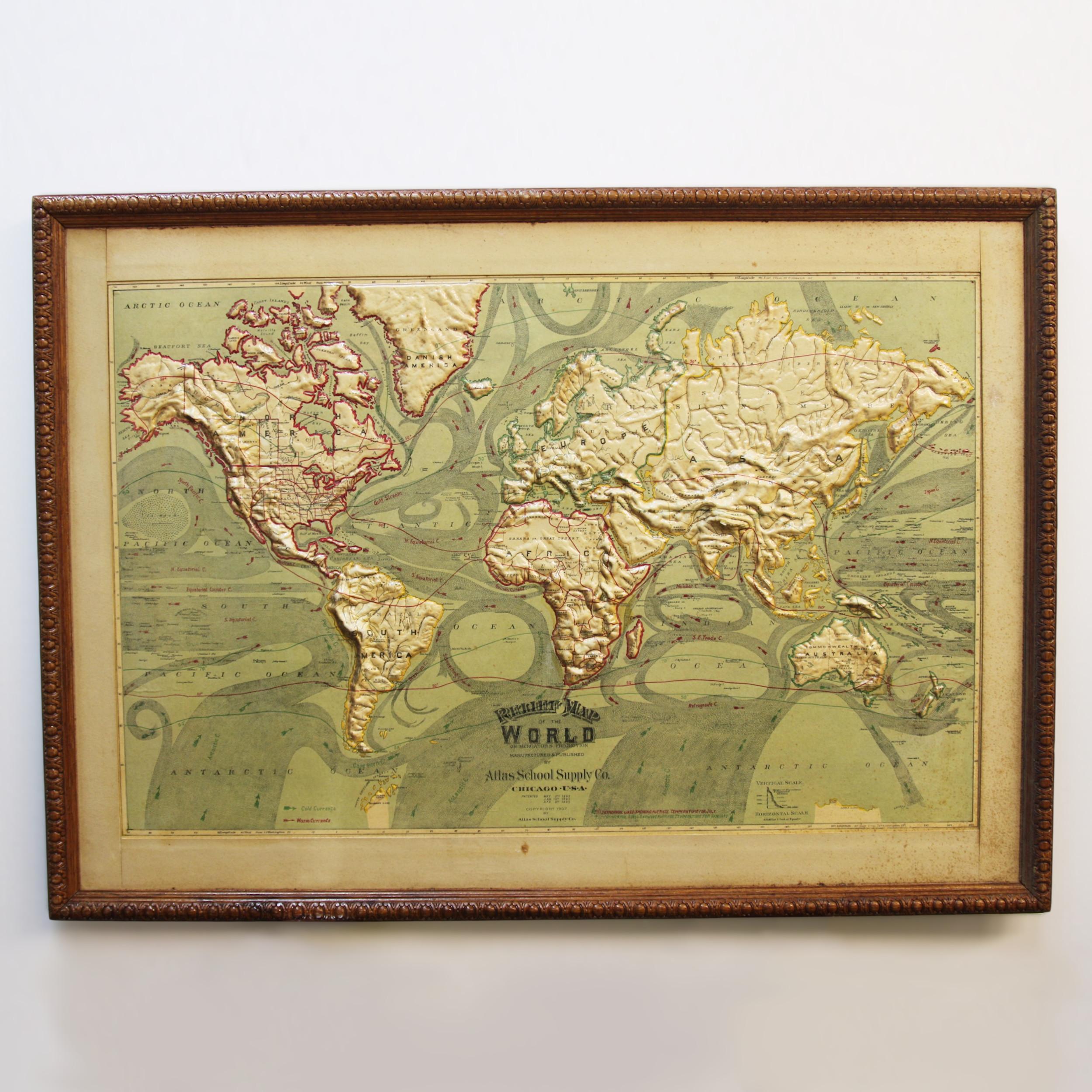 Remarkably original, 1907 relief map of world by the Atlas School Supply Co. of Chicago, Illinois. This exceptional quality map features its original oak frame, heavy-duty stretcher, bold graphics and beautifully molded 3-D papier mâché topography.