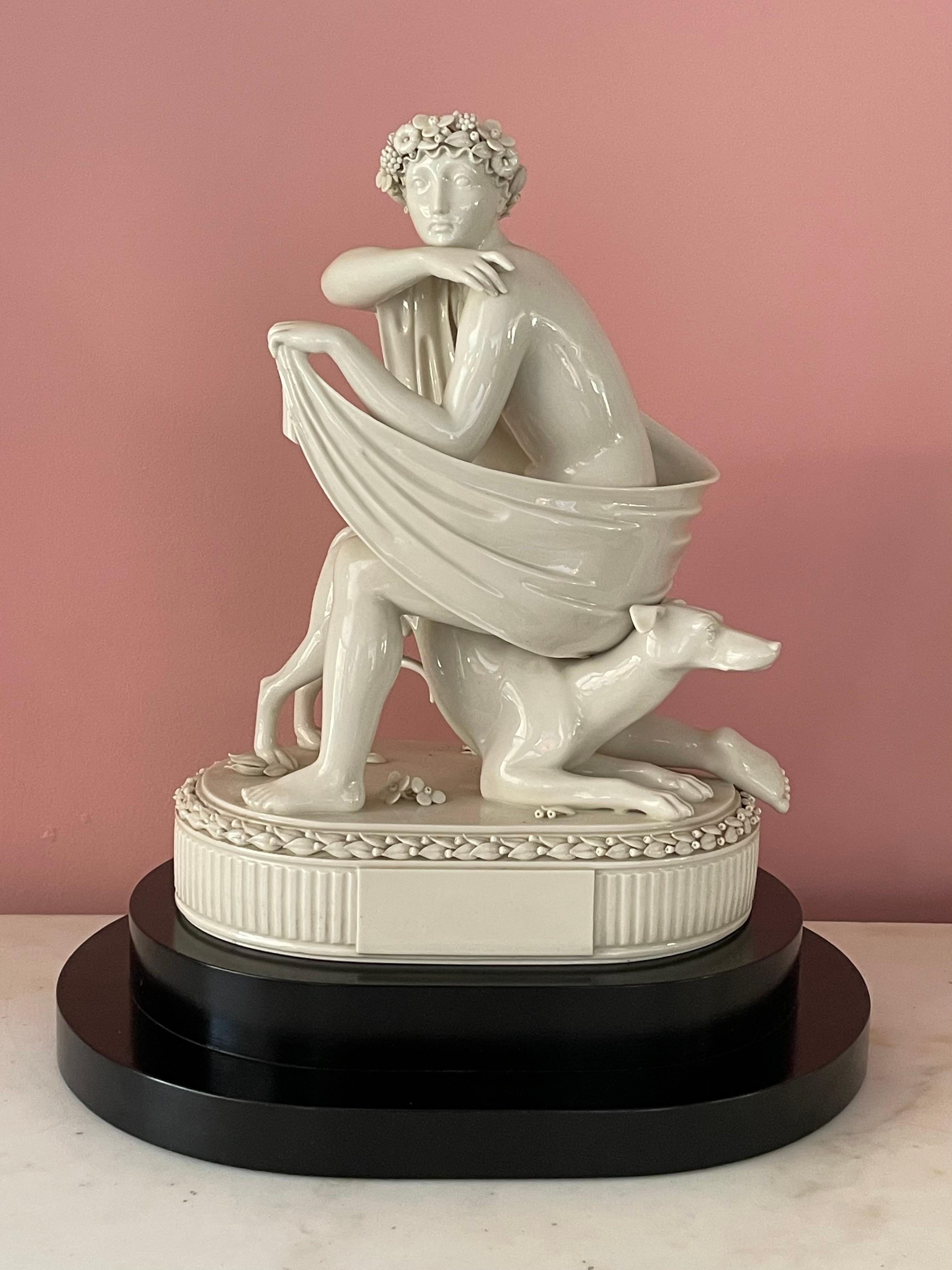 Cette sculpture en porcelaine Royal Copenhagen de 1927 est d'une taille exceptionnelle et semble représenter une amazone et son chien. Elle est remarquable par la juxtaposition des formes simplifiées de ses membres et de sa base, que l'on retrouve