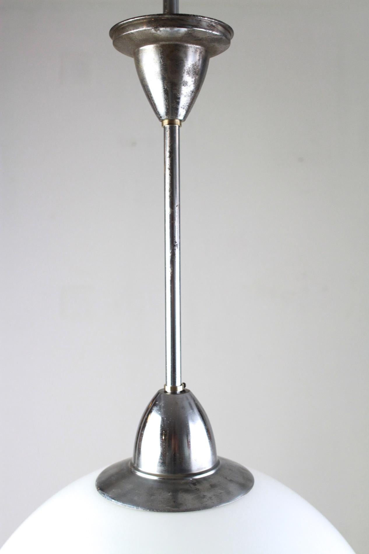 Large size Art Deco pendant with a flawless, geometric, stepped milk glass globe. The other parts are chrome-plated. It features a new E27 socket and new cables inside.
 