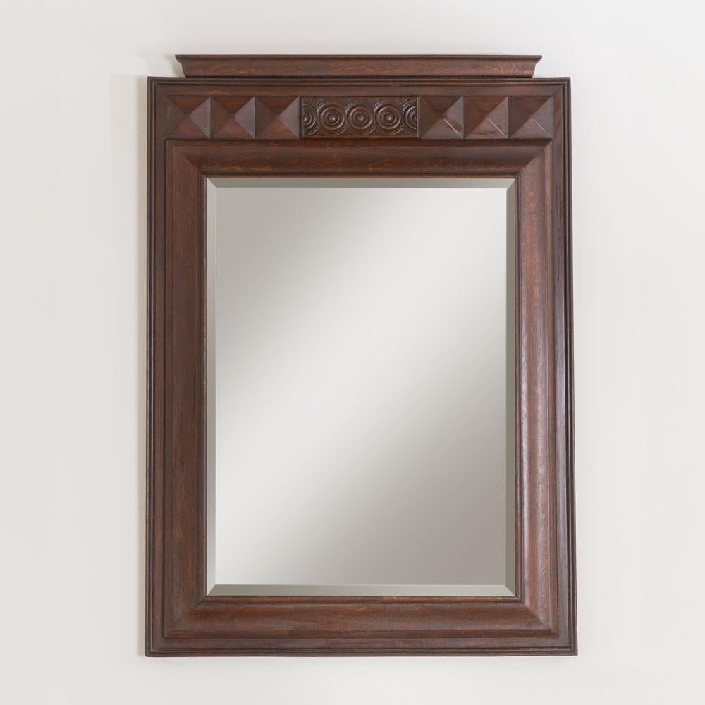 Impressionante specchio in legno intagliato, grande e pesante, proveniente dalla Francia, anni '40. Bellissima cornice rettangolare in legno scuro con dettagli intagliati sulla parte superiore. Un pezzo unico che si fa notare. 