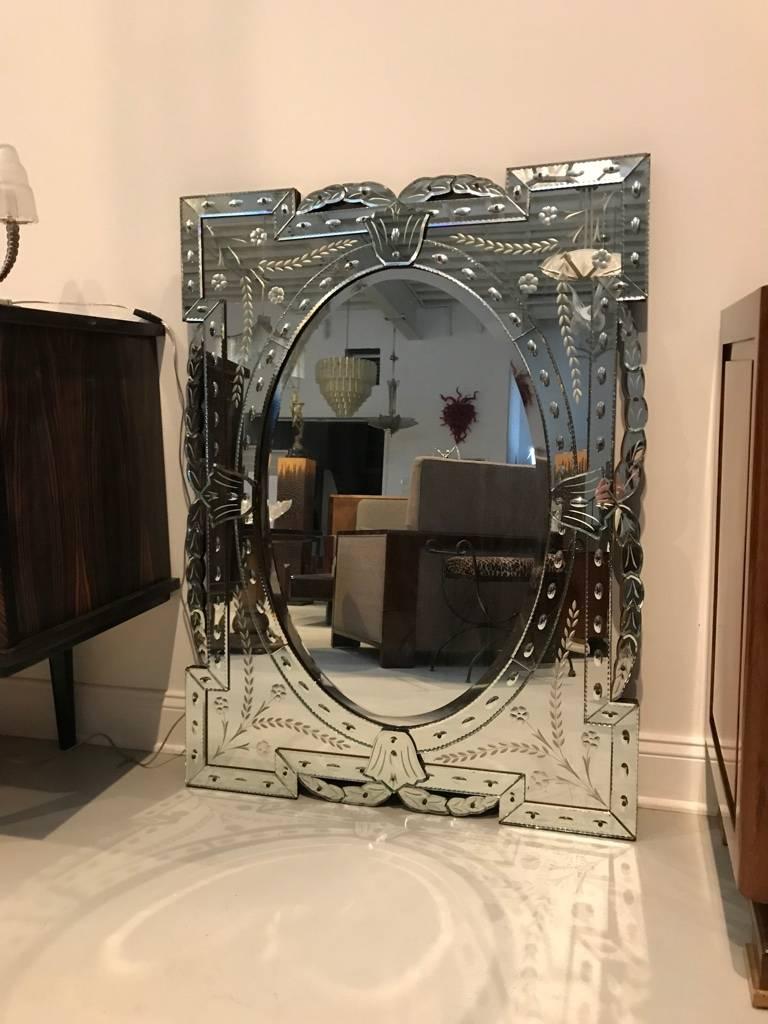 This gorgeous 1940s Hollywood style Venetian mirror features stylized scroll forms surrounding the geometric frame. In excellent condition. Ready for hanging. 

 