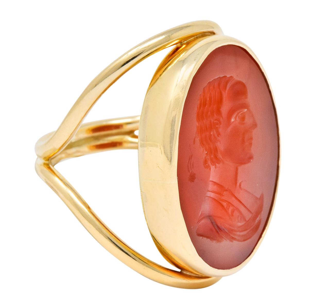 Centering a bezel set carnelian intaglio depicting the silhouette of a man with a small celestial symbol

Deeply carved intaglio measures 29 mm x 19 mm

Presented in a stylized simplistic high polished 14 karat gold mounting

Tested as 14 karat gold